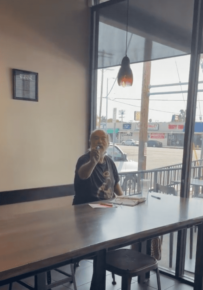 An older man sitting at the table compliments a Starbucks customer in the store | Photo: TikTok/rosette_luve
