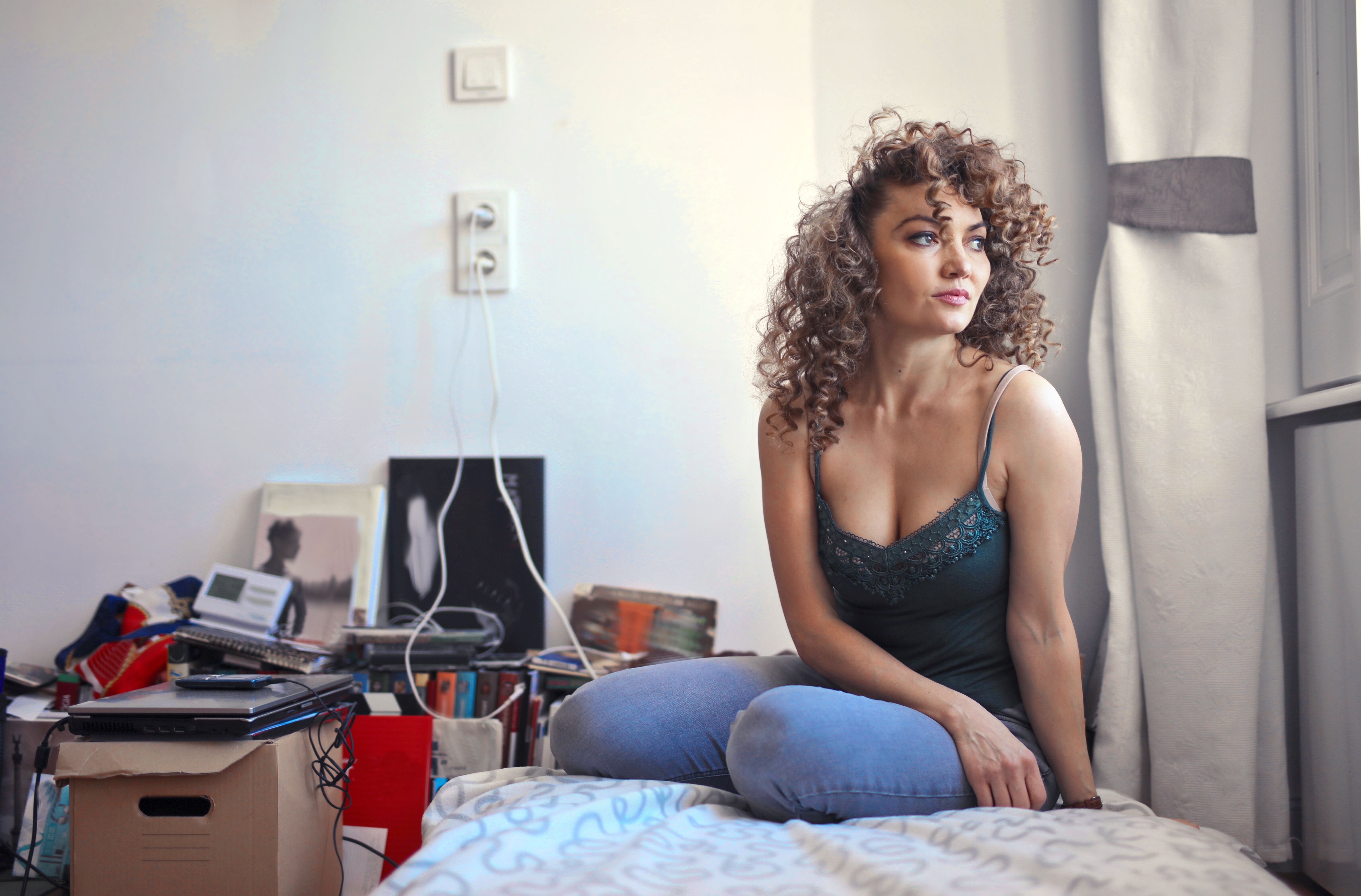 A woman looking out the window with cluttered behind her | Source: Pexels
