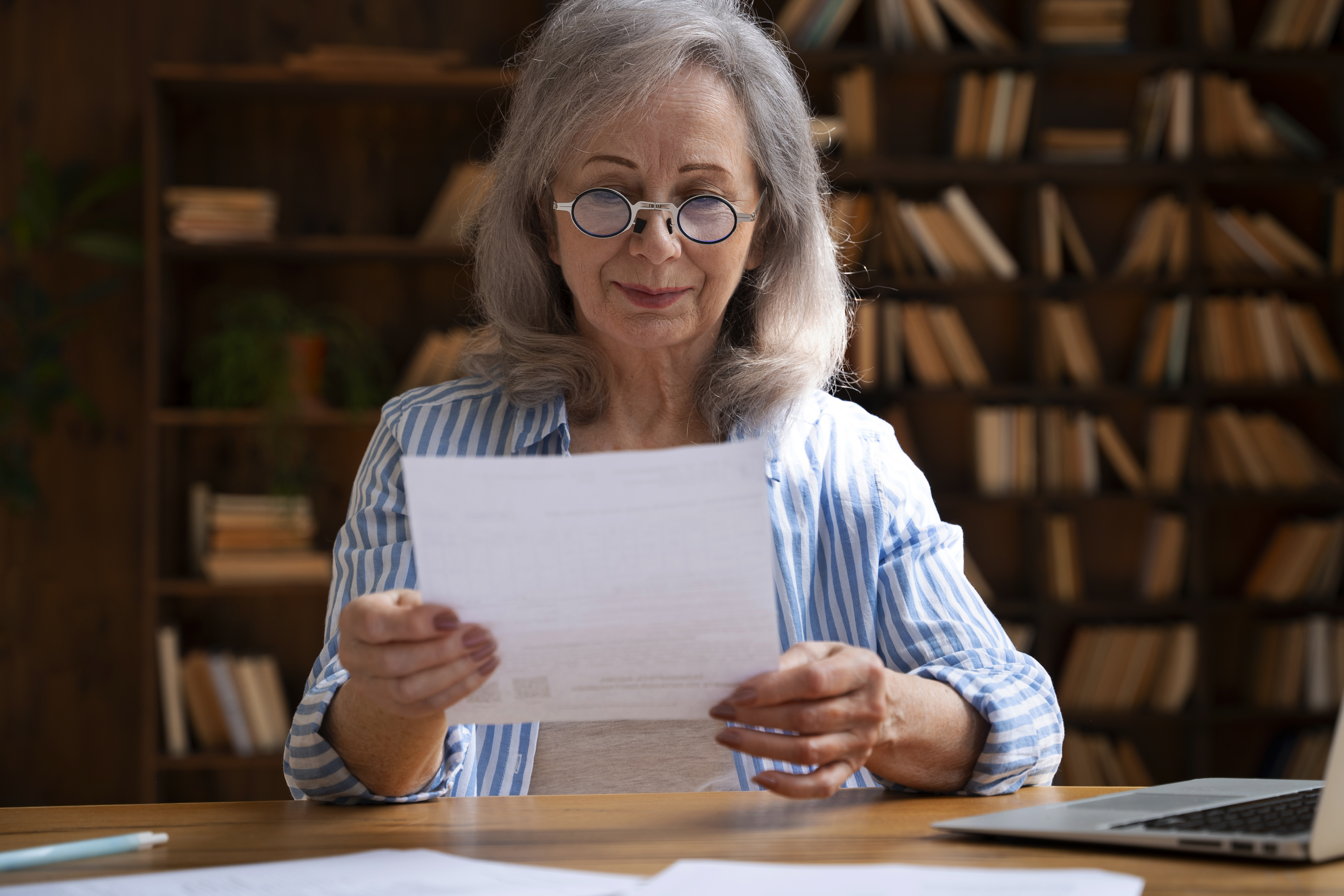 A woman smiling while reading a letter | Source: Freepik