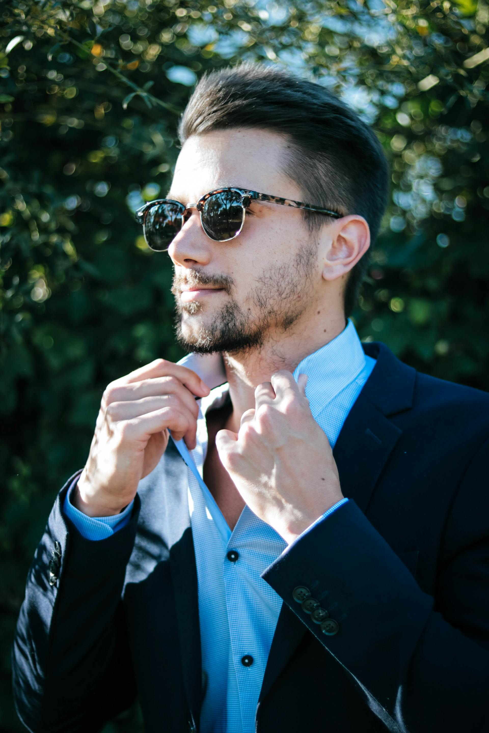 A man buttoning his shirt collar | Source: Pexels