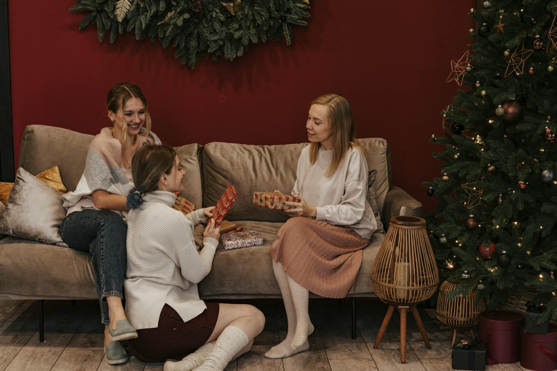 Women in a living room holding Christmas gifts | Source: Pexels