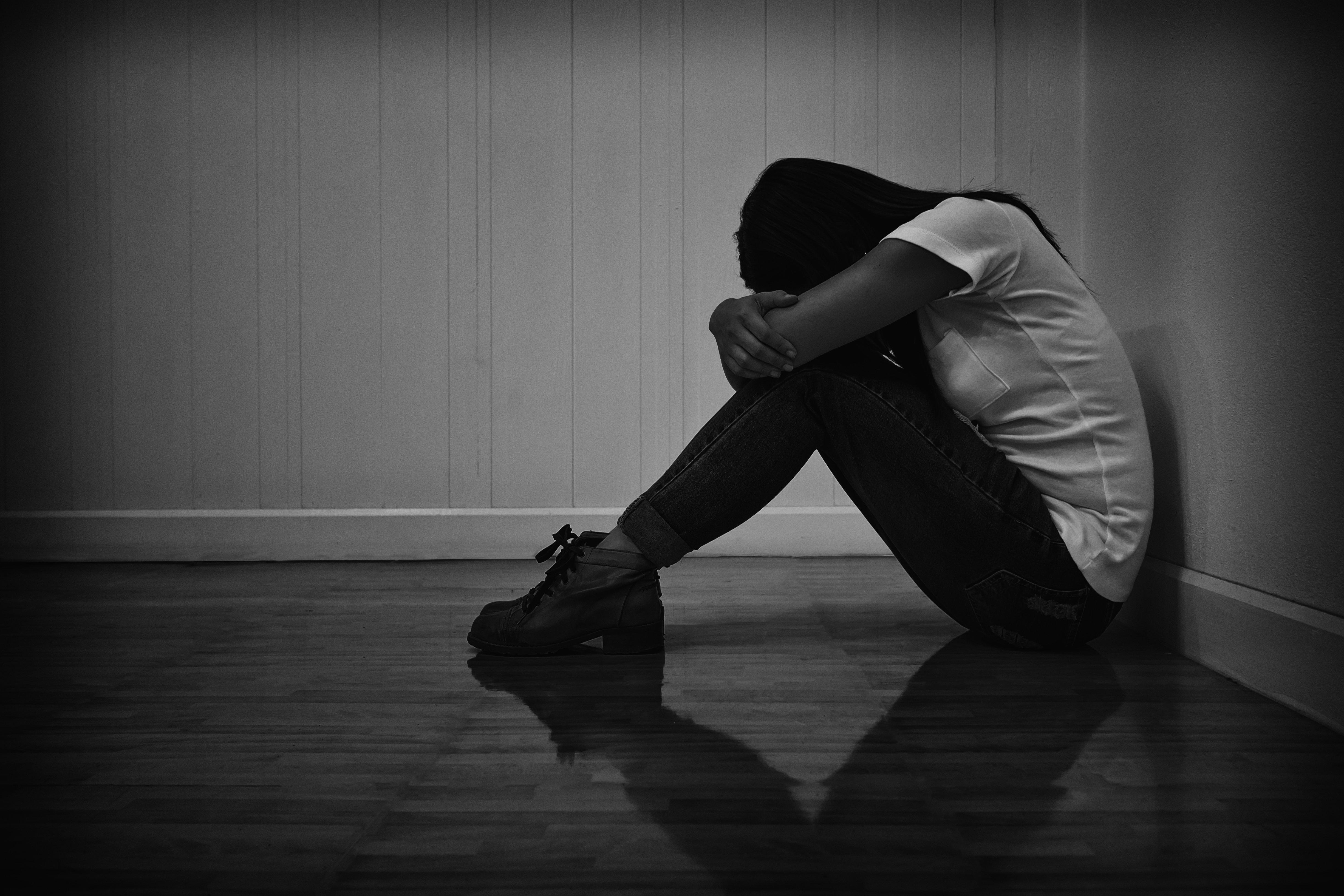 Woman sitting strain unhappy In a dark room. | Photo: Shutterstock