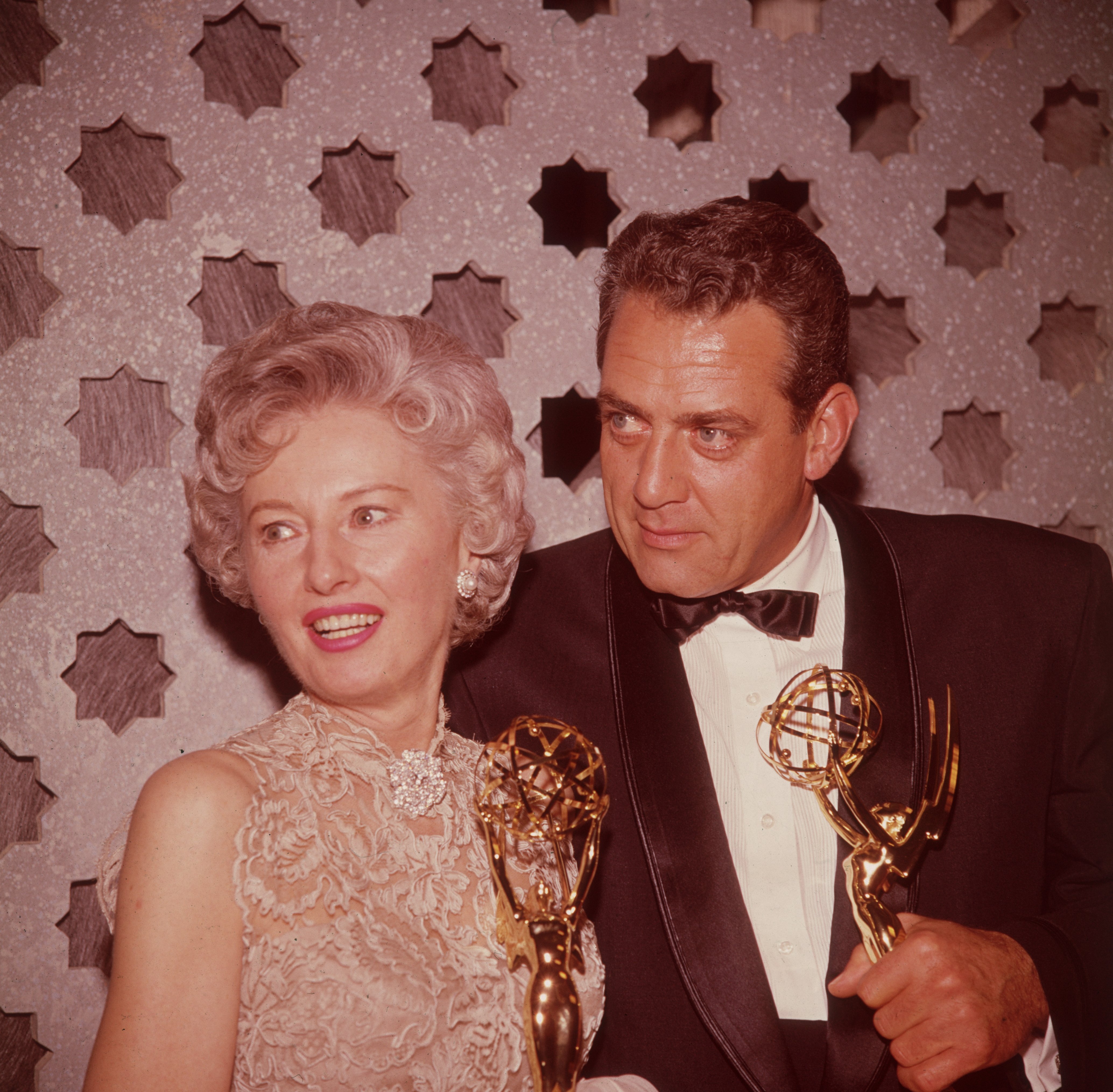 Raymond Burr and actress Barbara Stanwyck pictured holding Emmy Awards backstage in 1961. / Source: Getty Images