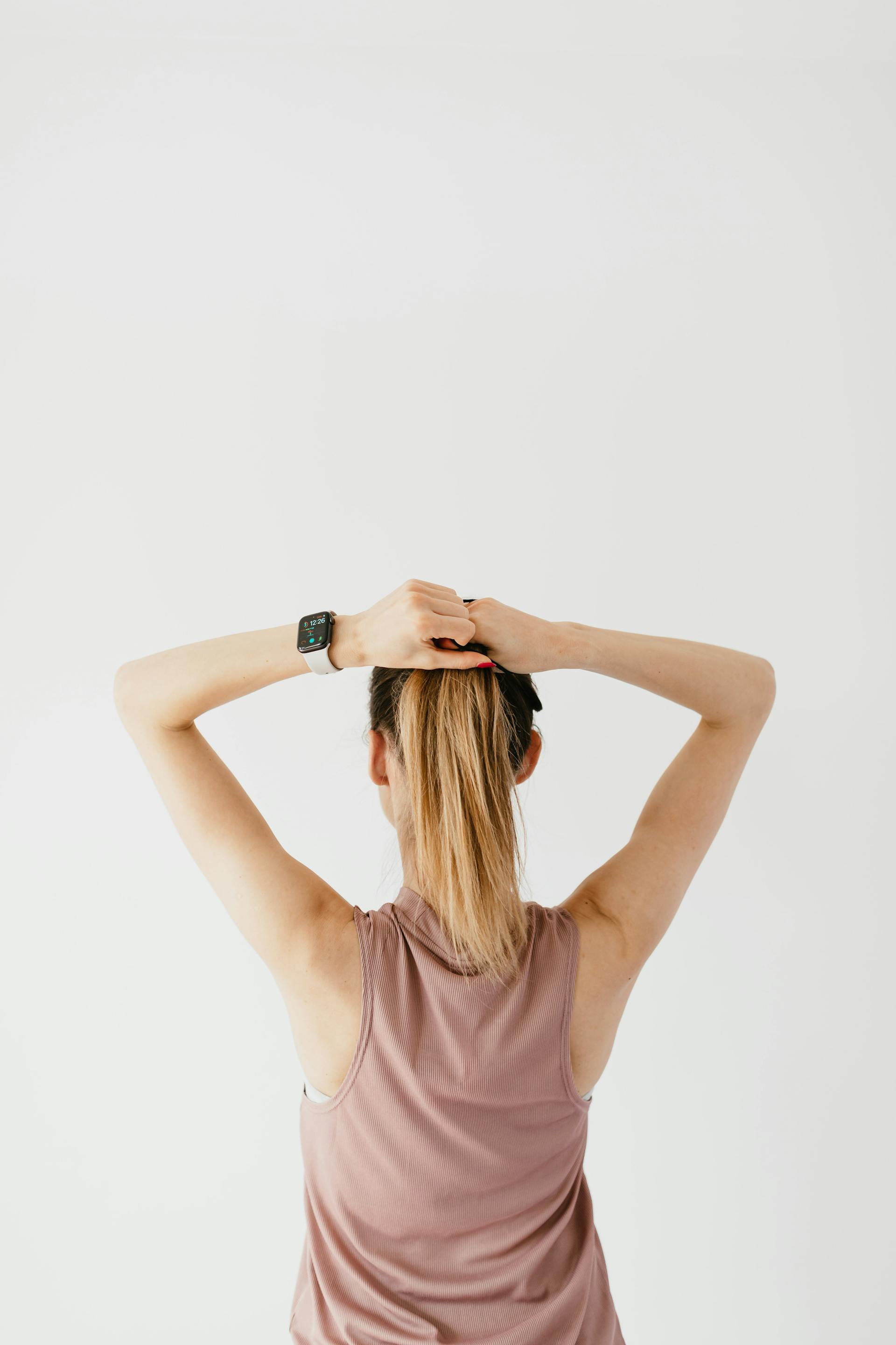 An unrecognizable woman making a ponytail | Source: Pexels