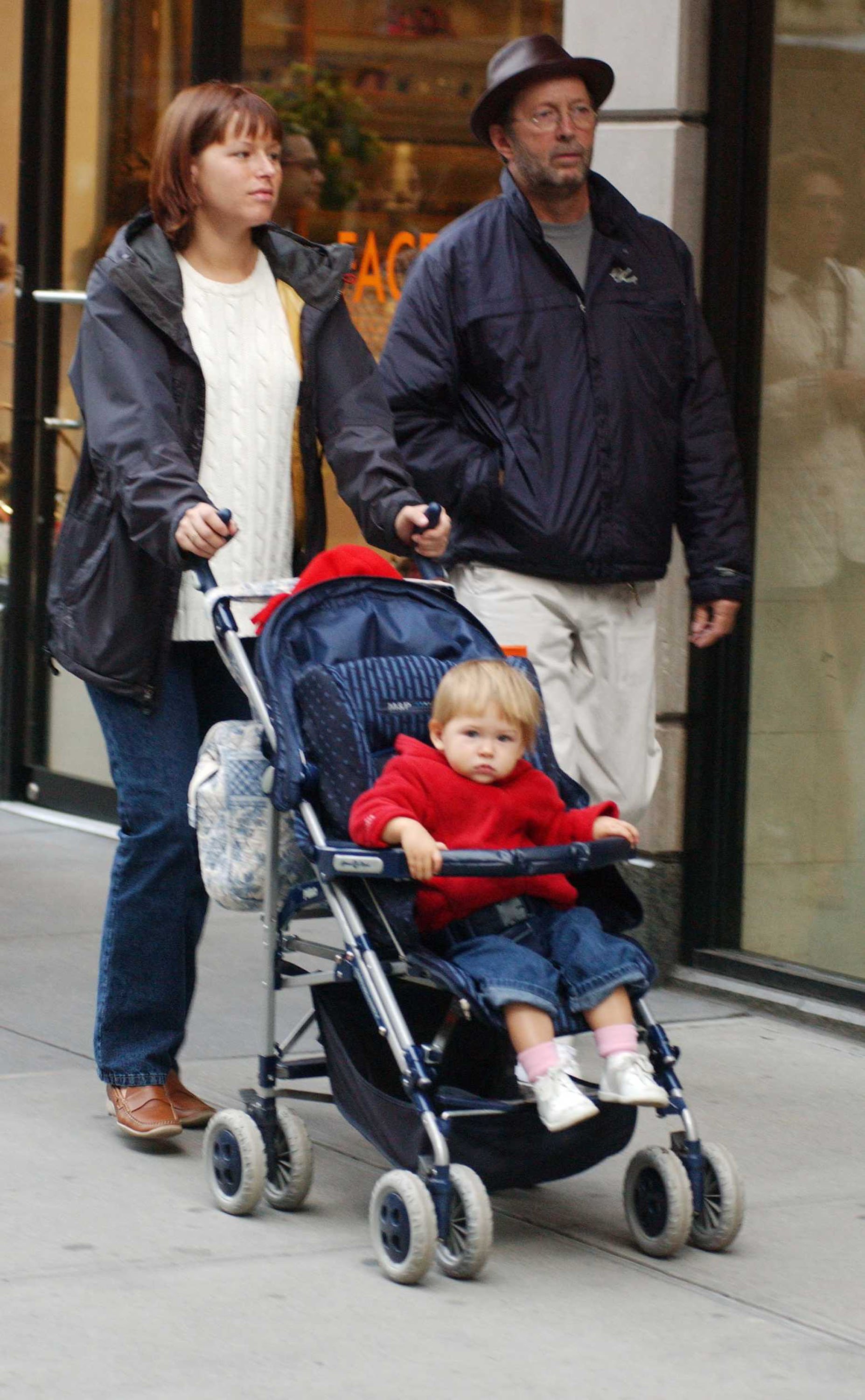 Eric Clapton and Melia McEnery shopping on Madison Avenue with their daughter on October 28, 2002, in New York City | Source: Getty Images