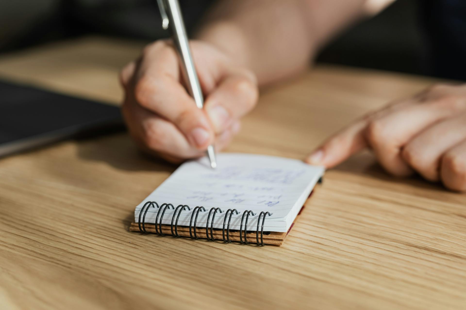 Person writing a note | Source: Pexels