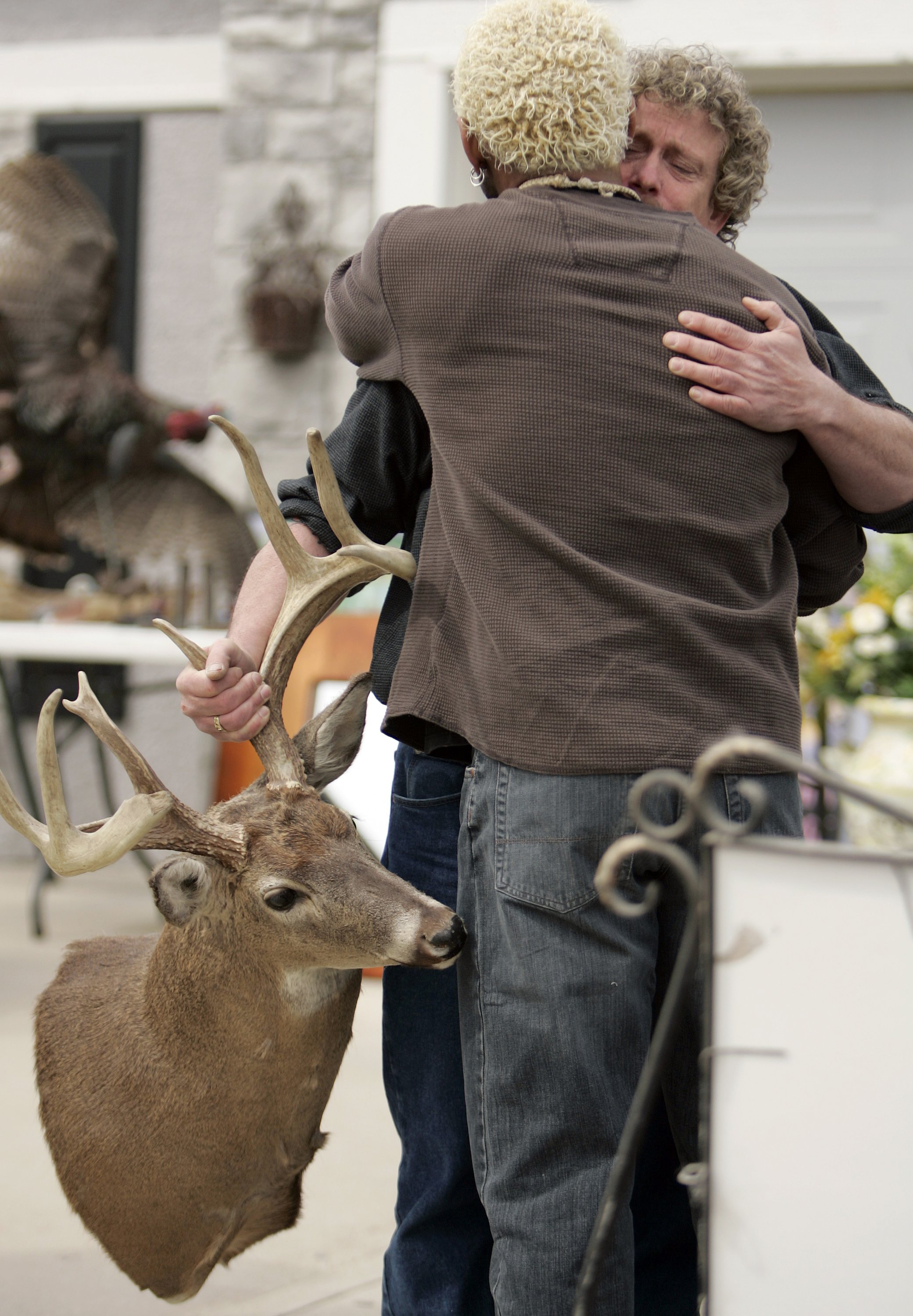 Willie Aames gets a hug at the start of his garage sale in Olathe, Kansas, on Thursday, March 26, 2009. | Source: Getty Images