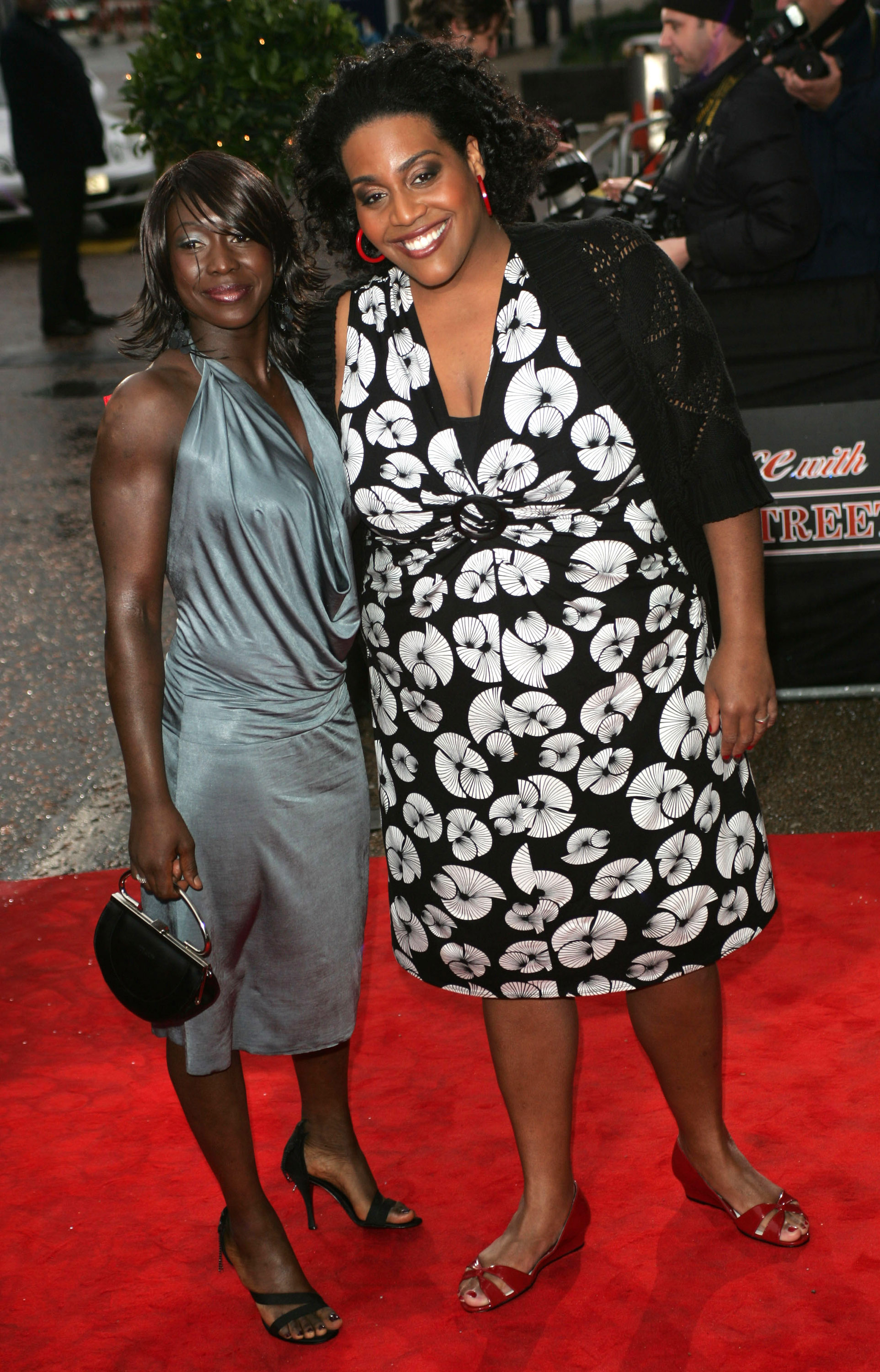 Beaming beside a guest, Hammond arrives arm-in-arm at the red carpet for "An Audience with 'Coronation Street'" at ITV Studios, London, on 9 April 2006. Her black dress pops with bold white florals and red accessories as she shares a warm smile with photographers.