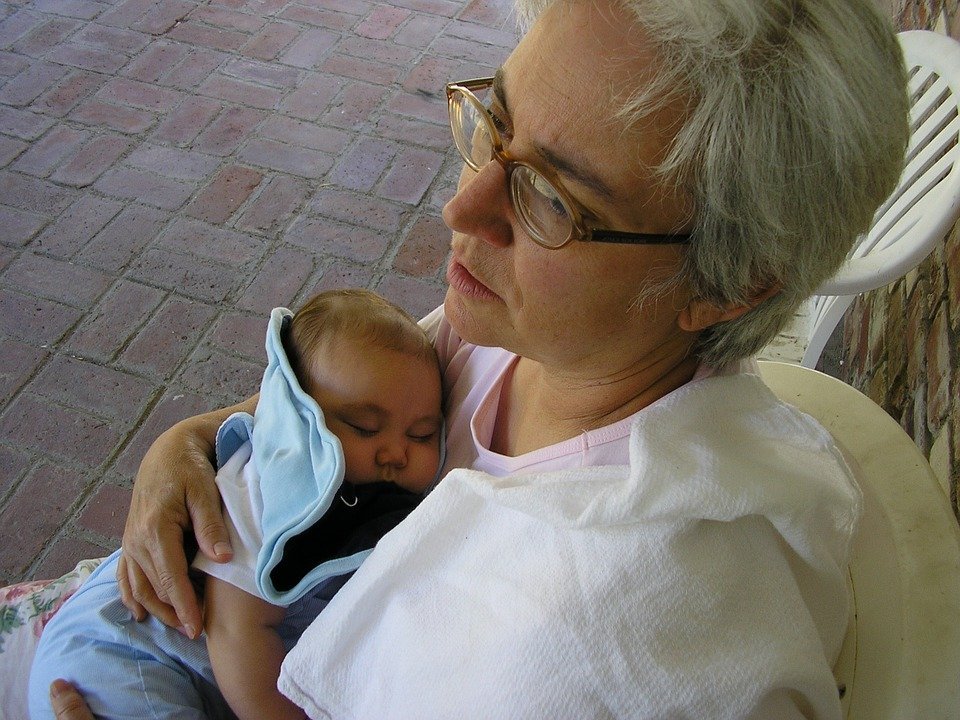Mujer adulta sosteniendo a bebé pequeño. | Foto: Pixabay