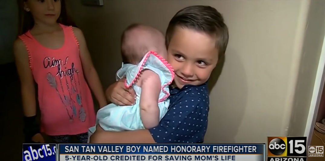 Salvatore Cicalese holding his baby sister in news coverage after he helped save their mother's life in an April 15, 2014, YouTube clip | Source: YouTube/ABC15 Arizona