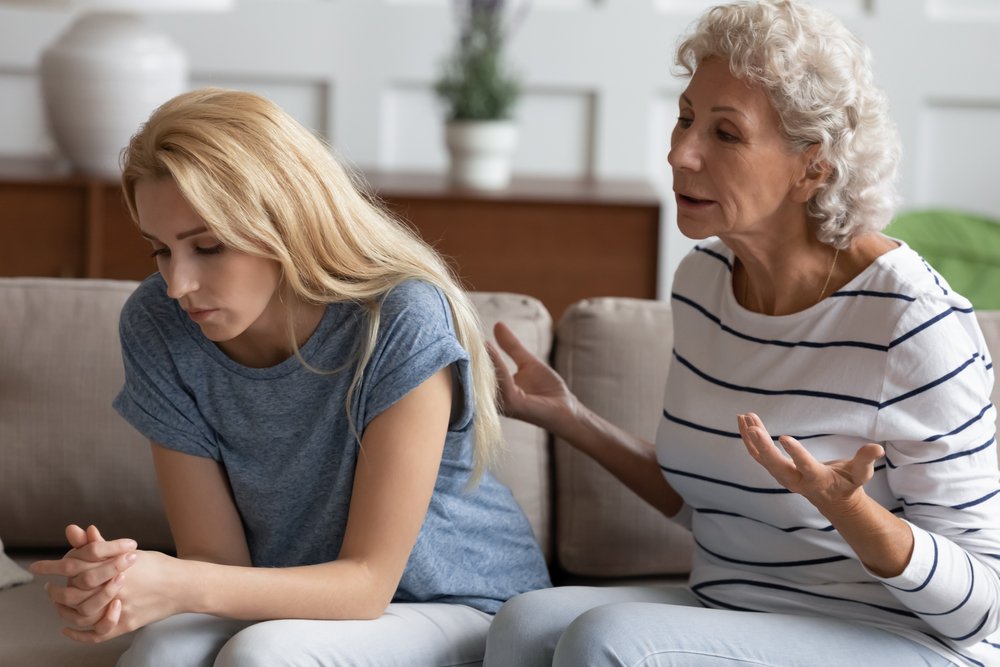 Una madre conversando con su hija sentadas en un sofá. | Foto: Shutterstock