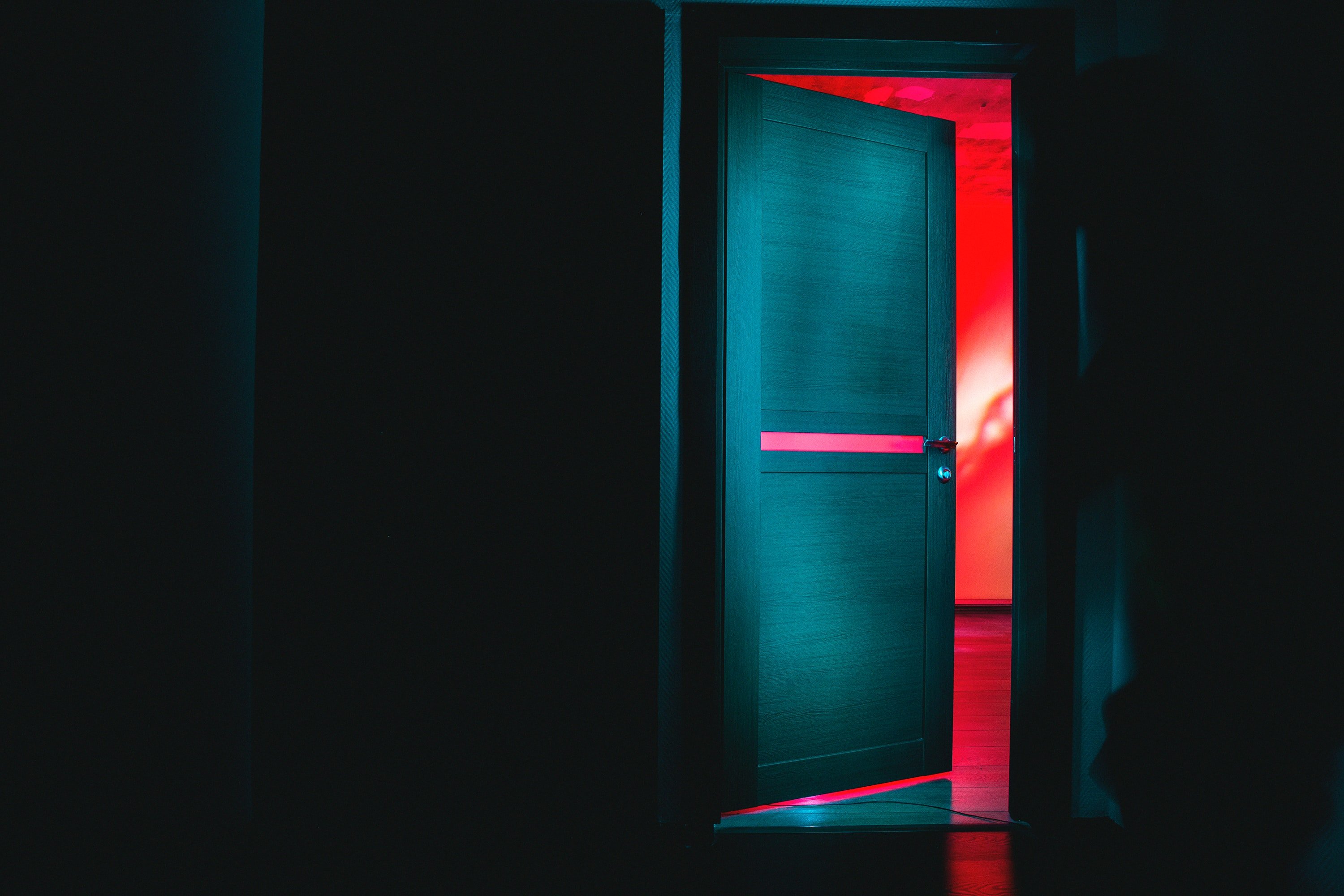 A black door opening into a red room | Photo: Unsplash