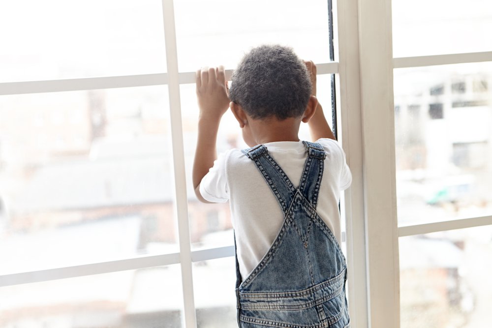 Niño mira por la ventana. | Foto: Shutterstock
