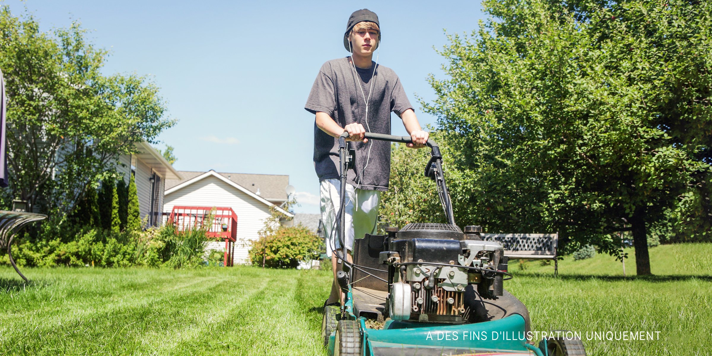 Un adolescent tondant la pelouse | Source : Shutterstock