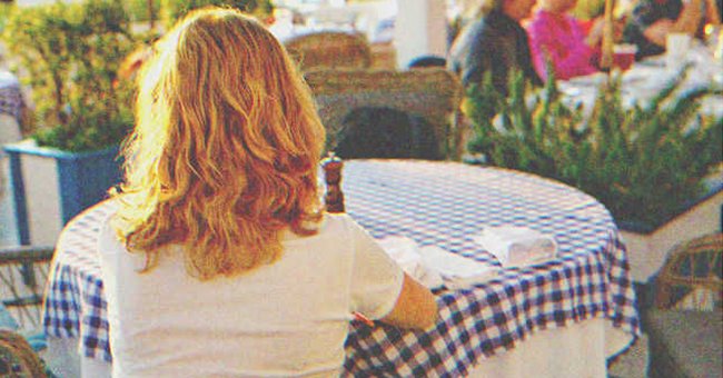 Mujer sentada en una mesa de un restaurante. | Foto: Shutterstock