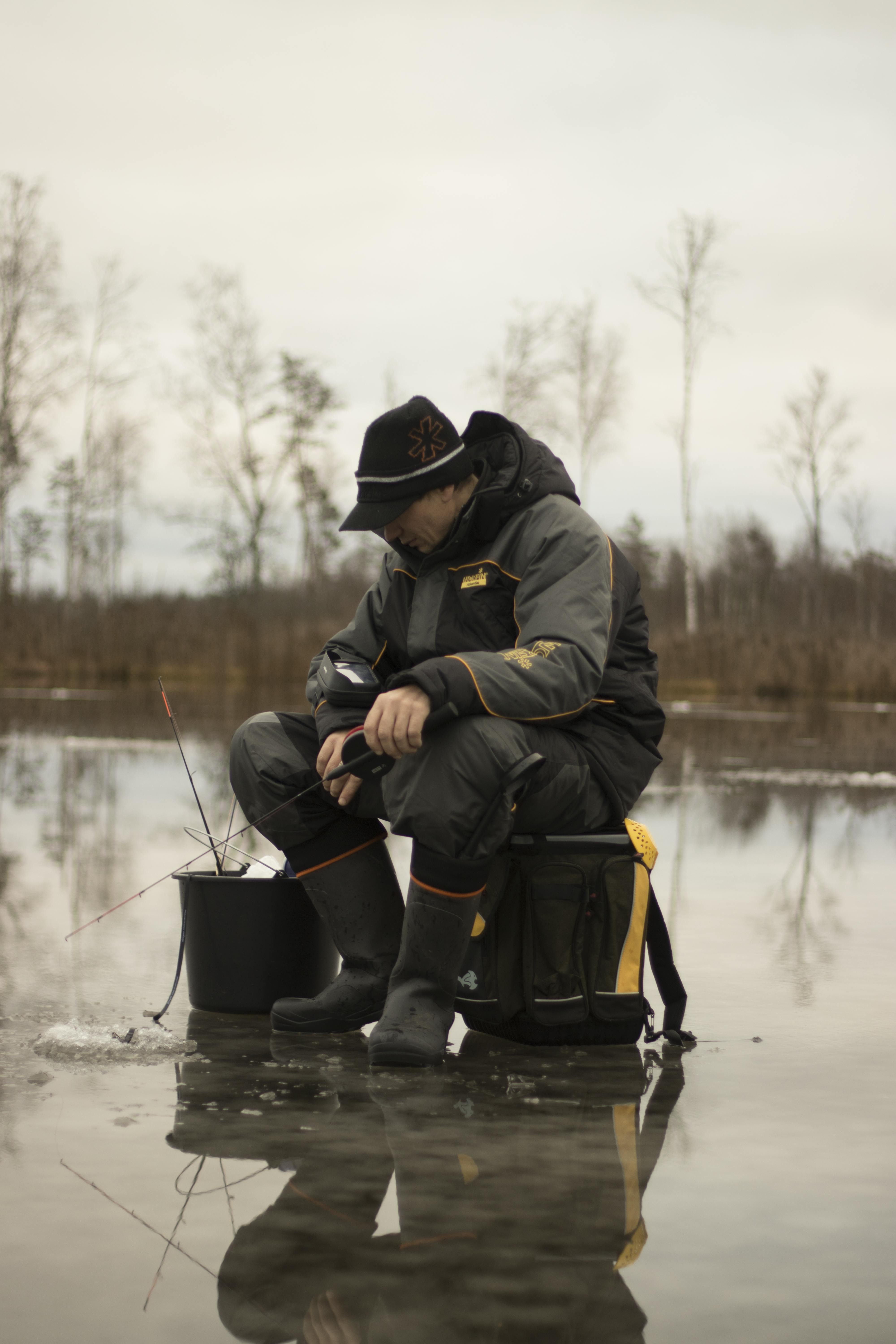 A man ice fishing on a frozen lake | Source: Pexels