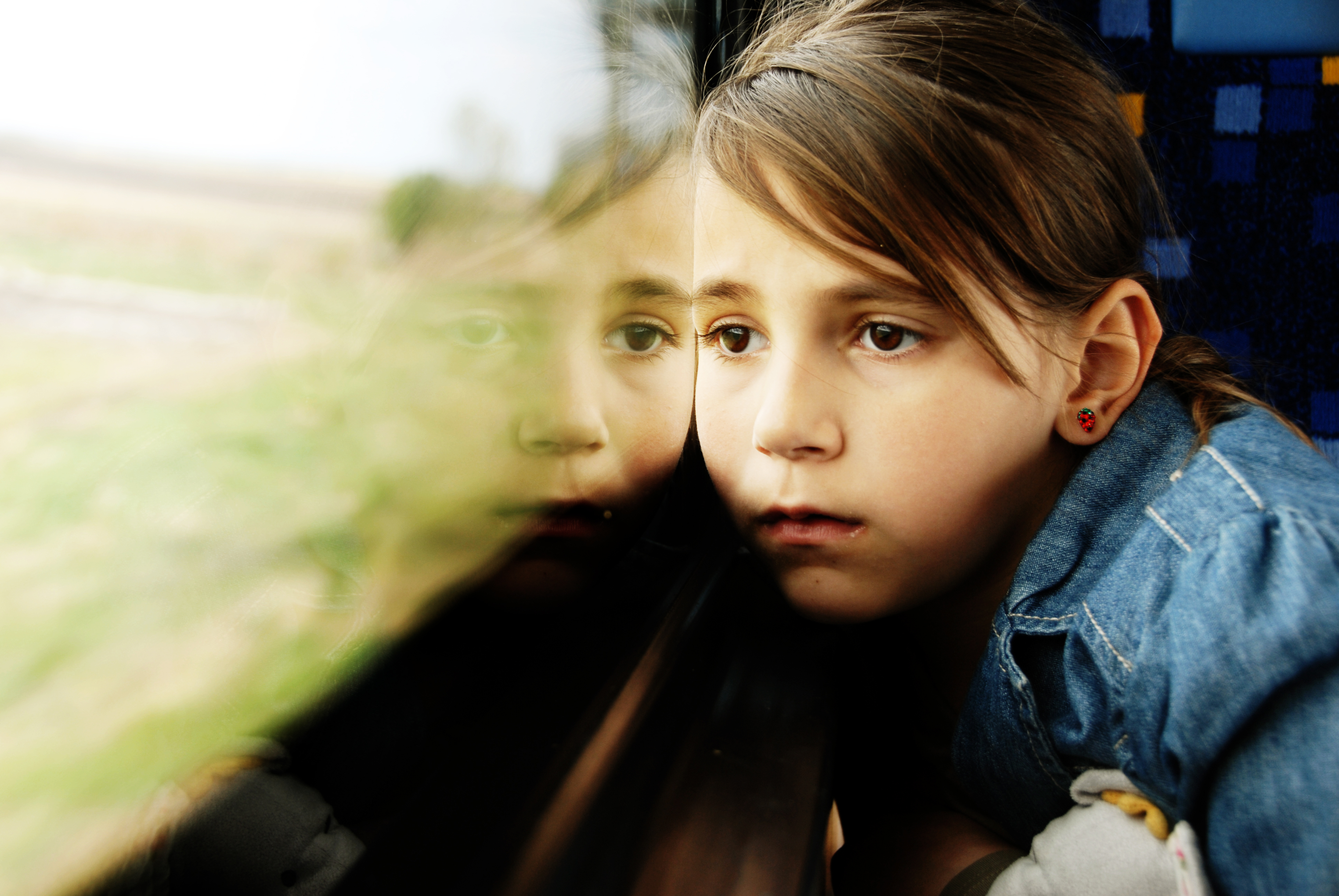 Little girl looking through window | Source: Shutterstock.com