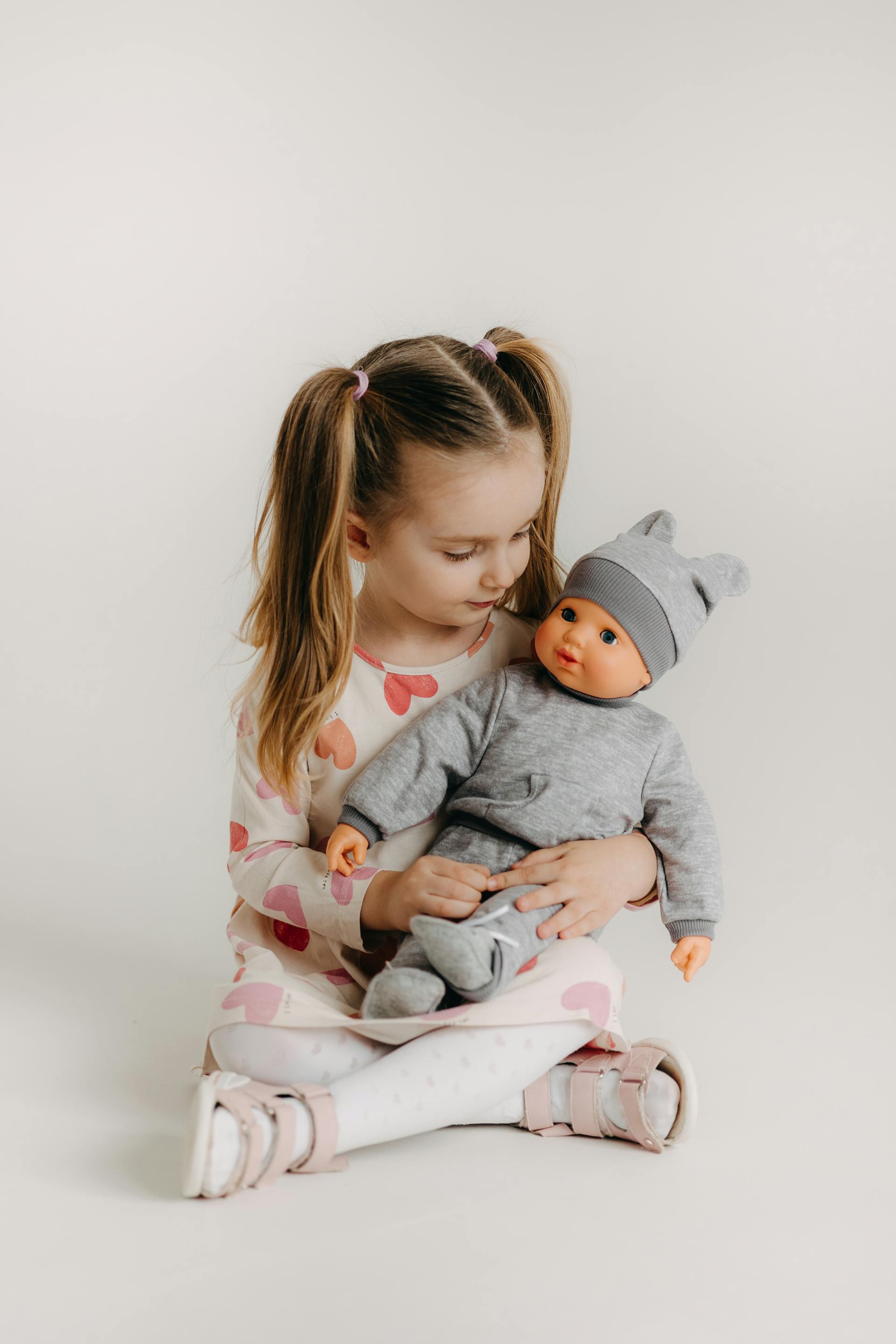 A little girl playing with a doll | Source: Pexels