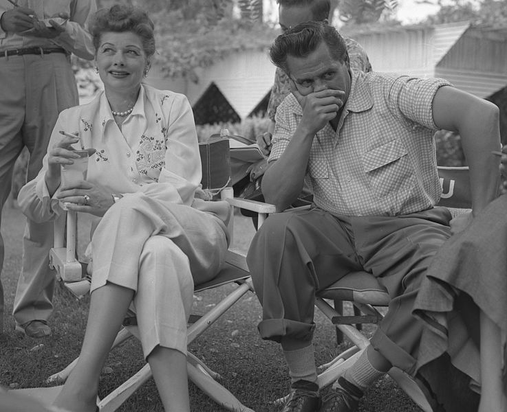  Lucille Ball and husband, Desi Arnaz seated in directors chairs at press conference in Los Angeles, California, circa 1953 | Photo: Public Domain, Wikimedia Commons