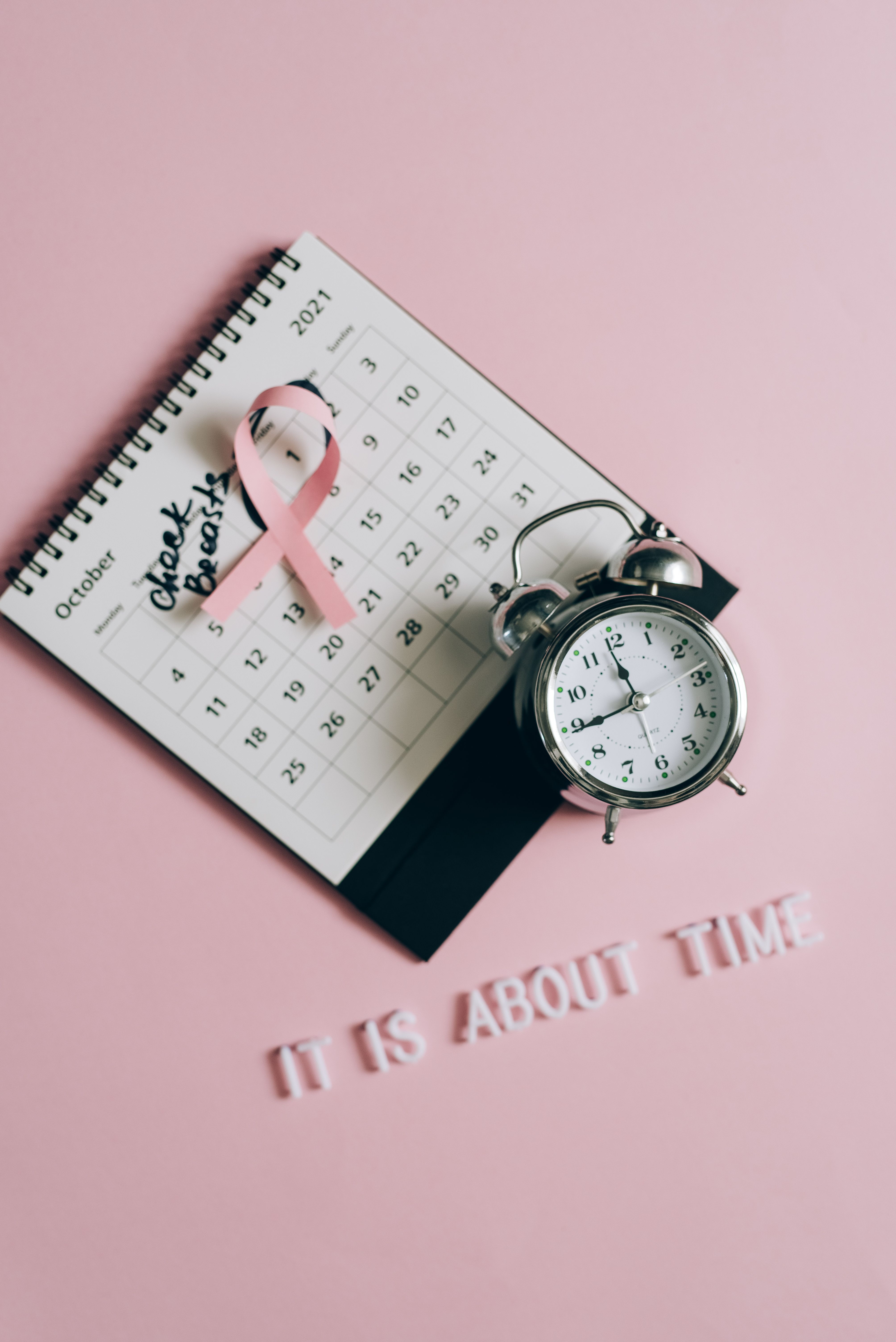 A calendar marking the date for a breast exam with a clock symbolizing time for a check-up"| Source: Pexels