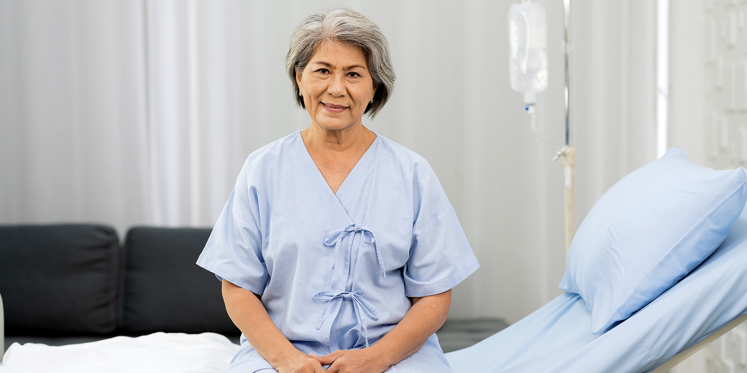 A old woman sitting on a hospital bed | Source: Shutterstock