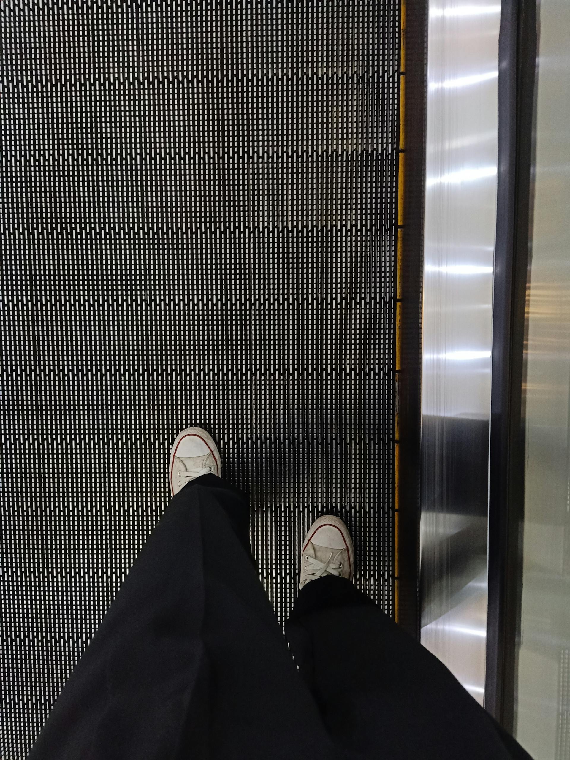 A person standing on a moving walkway | Source: Pexels