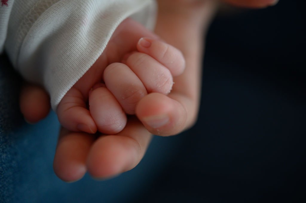 La mano de un recién nacido de dos semanas sobre la mano de su madre. | Foto: Getty Images