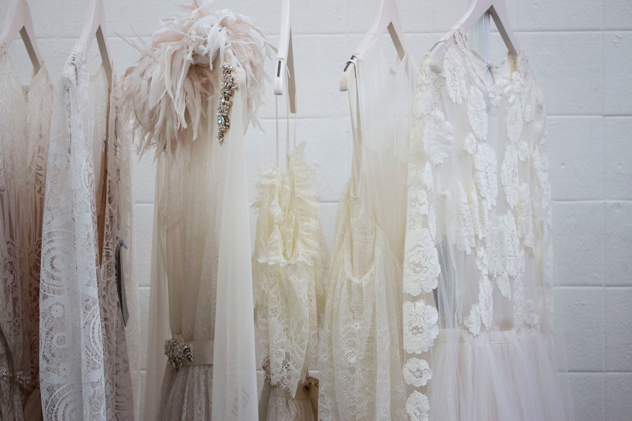 White dresses hanging on a stand | Source: Unsplash