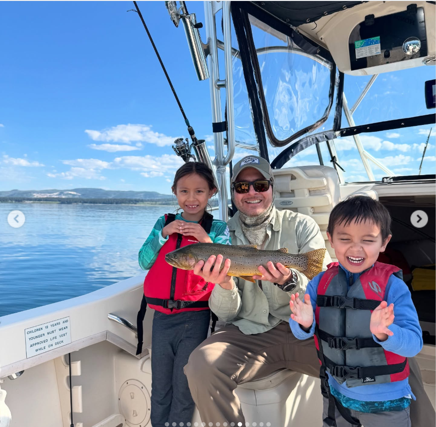 Matthew Mitchell poses on a boat with his two children as they celebrate another successful fishing trip under bright blue skies. | Source: Instagram/thy_travelers