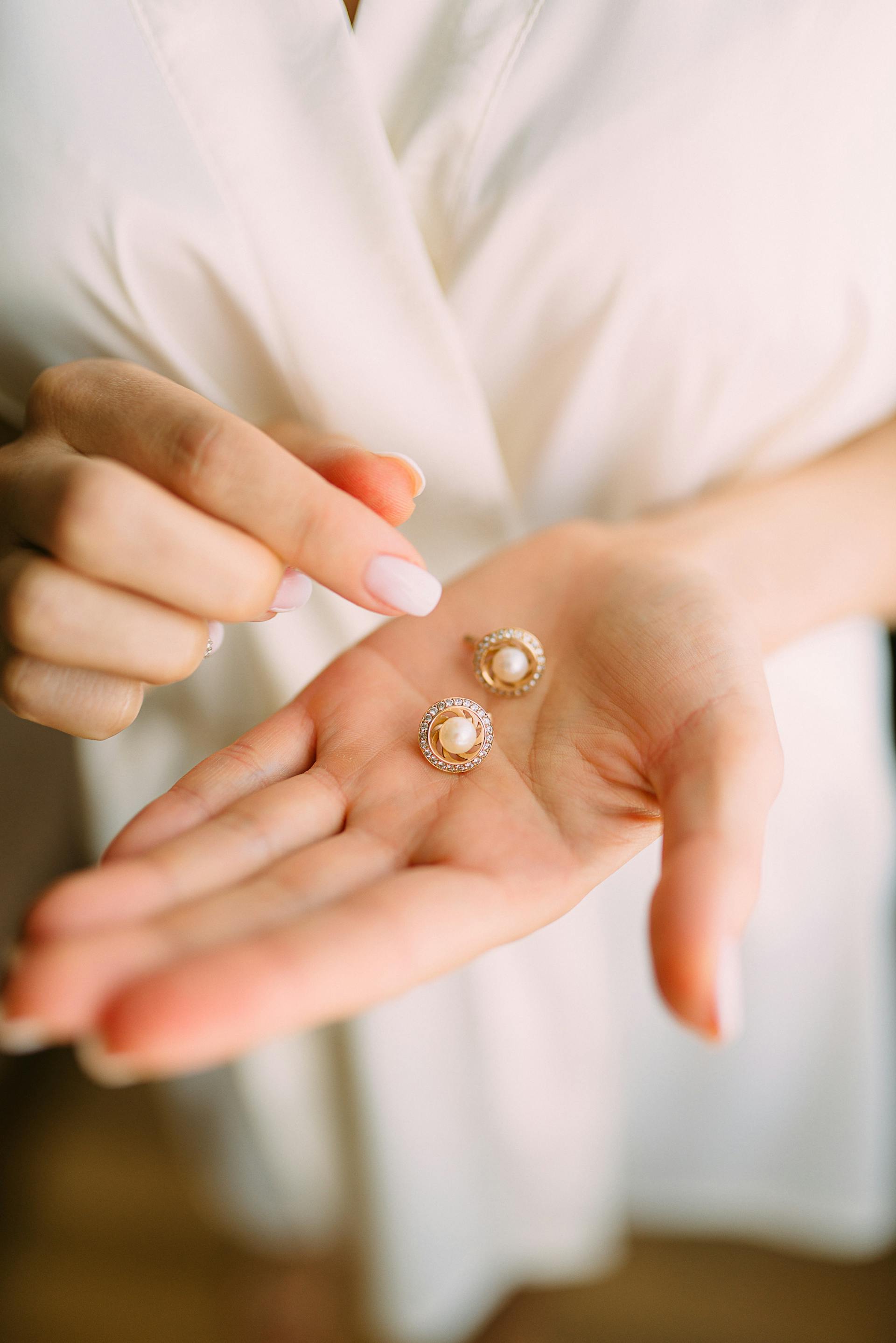 A closeup of a woman holding earrings | Source: Pexels