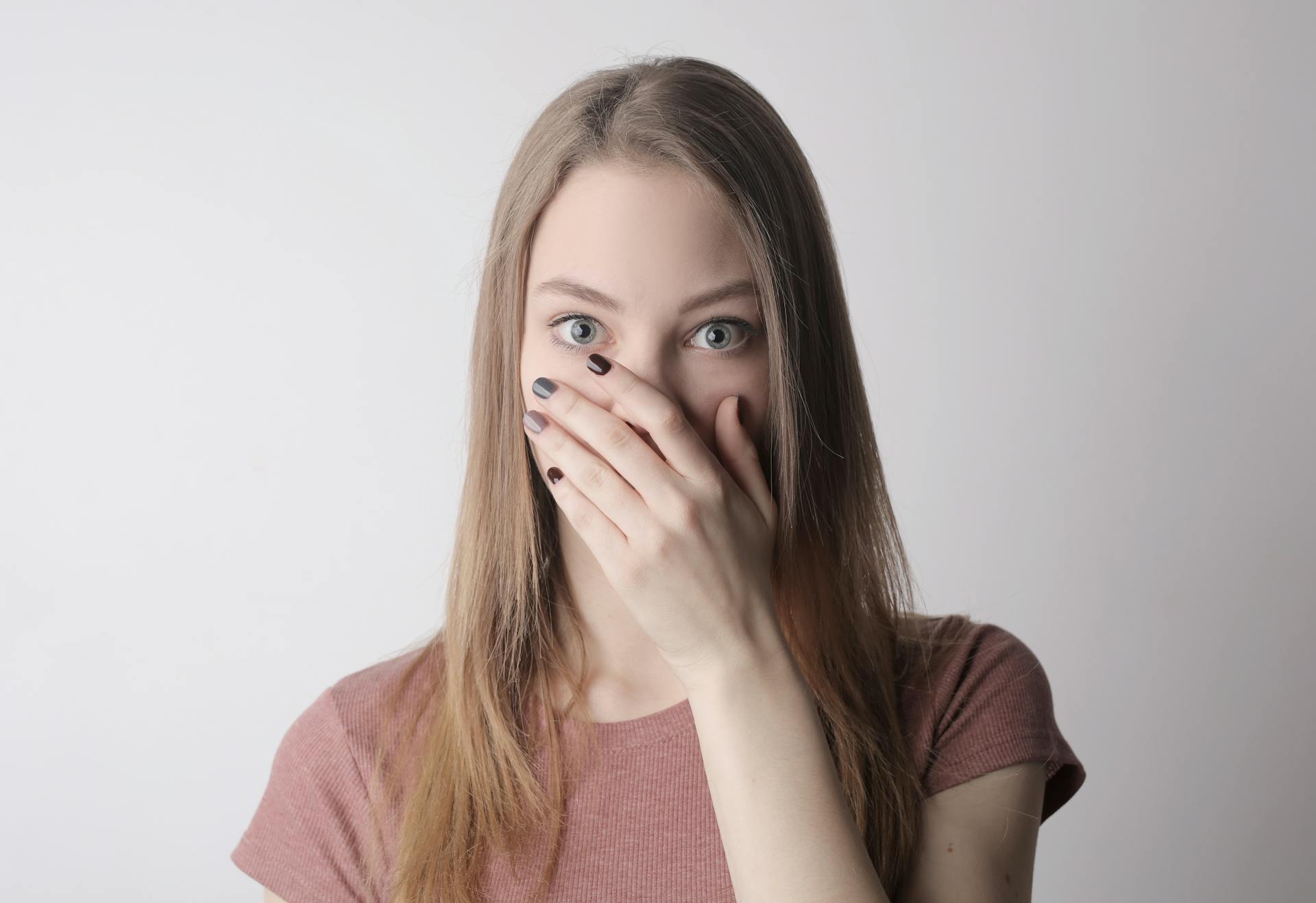 A shocked woman covering her mouth with her hand | Source: Pexels