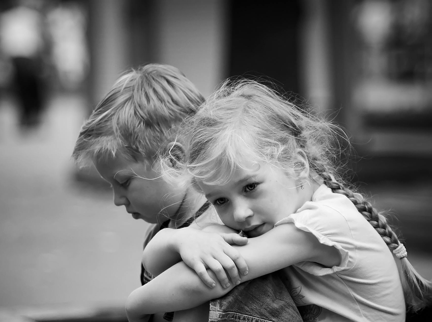 Grayscale of a sad little boy and girl sitting outside | Source: Pexels