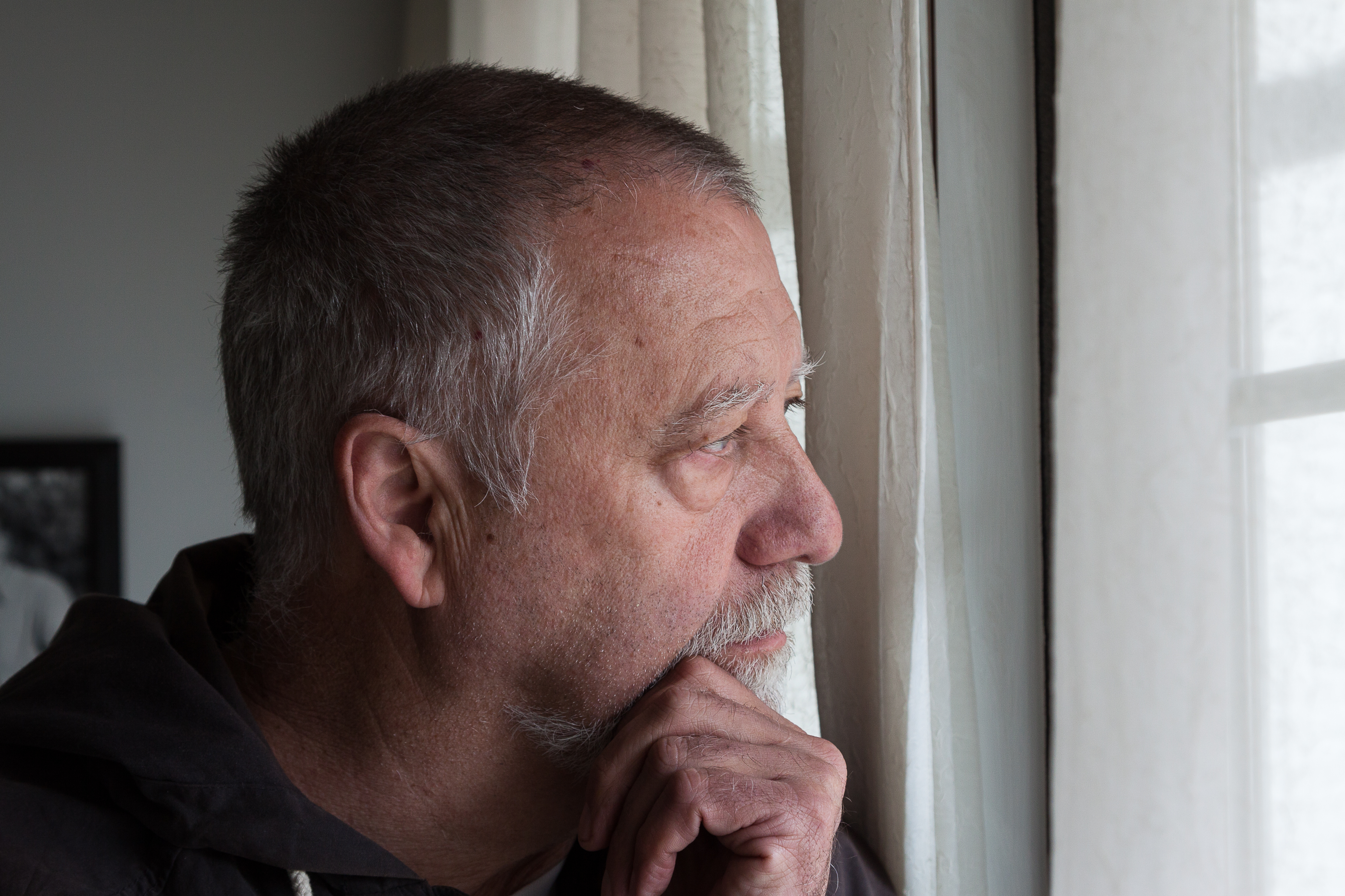 Sad man is staying near the window | Source: Shutterstock.com