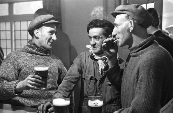 Three men having a drink in bar | Photo: Getty Images