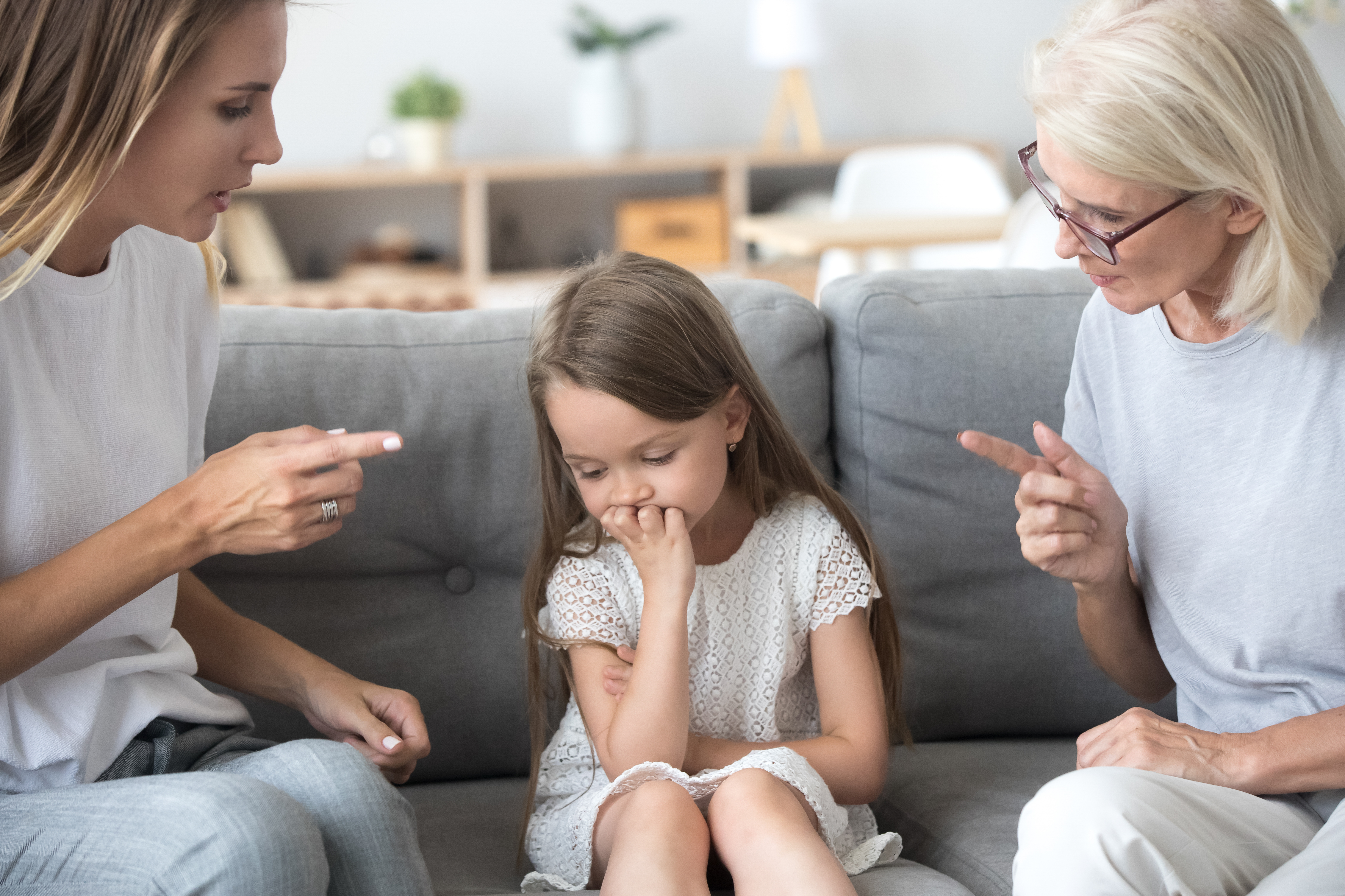 An angry young woman and an elderly lady lecturing a little girl | Source: Shutterstock