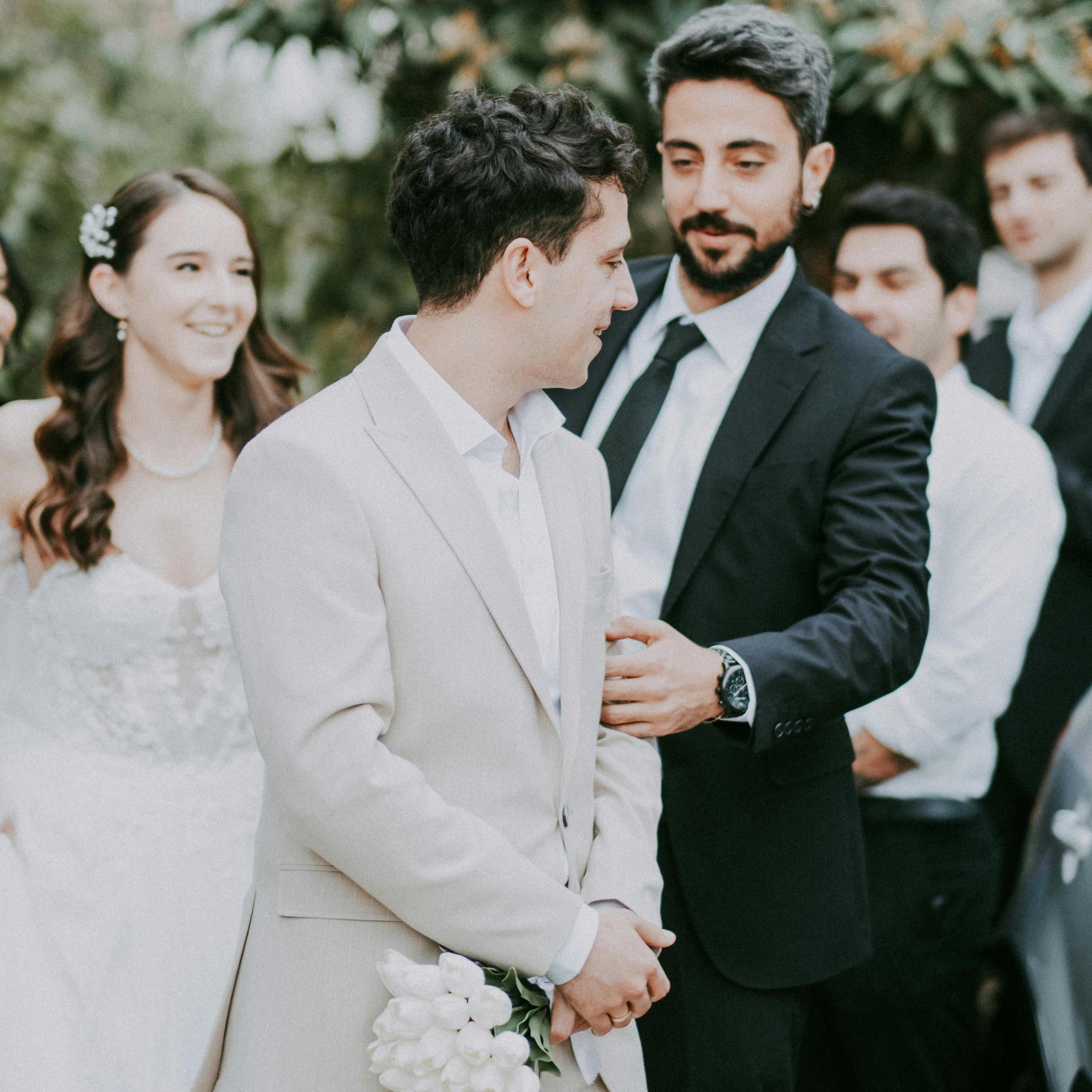 A groom surrounded by guests at a wedding reception | Source: Pexels