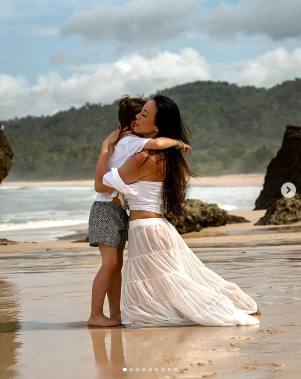 Christopher Woolf Mapelli Mozzi hugs his mother, Dara Huang, by the beach. | Source: Instagram/dara_huang