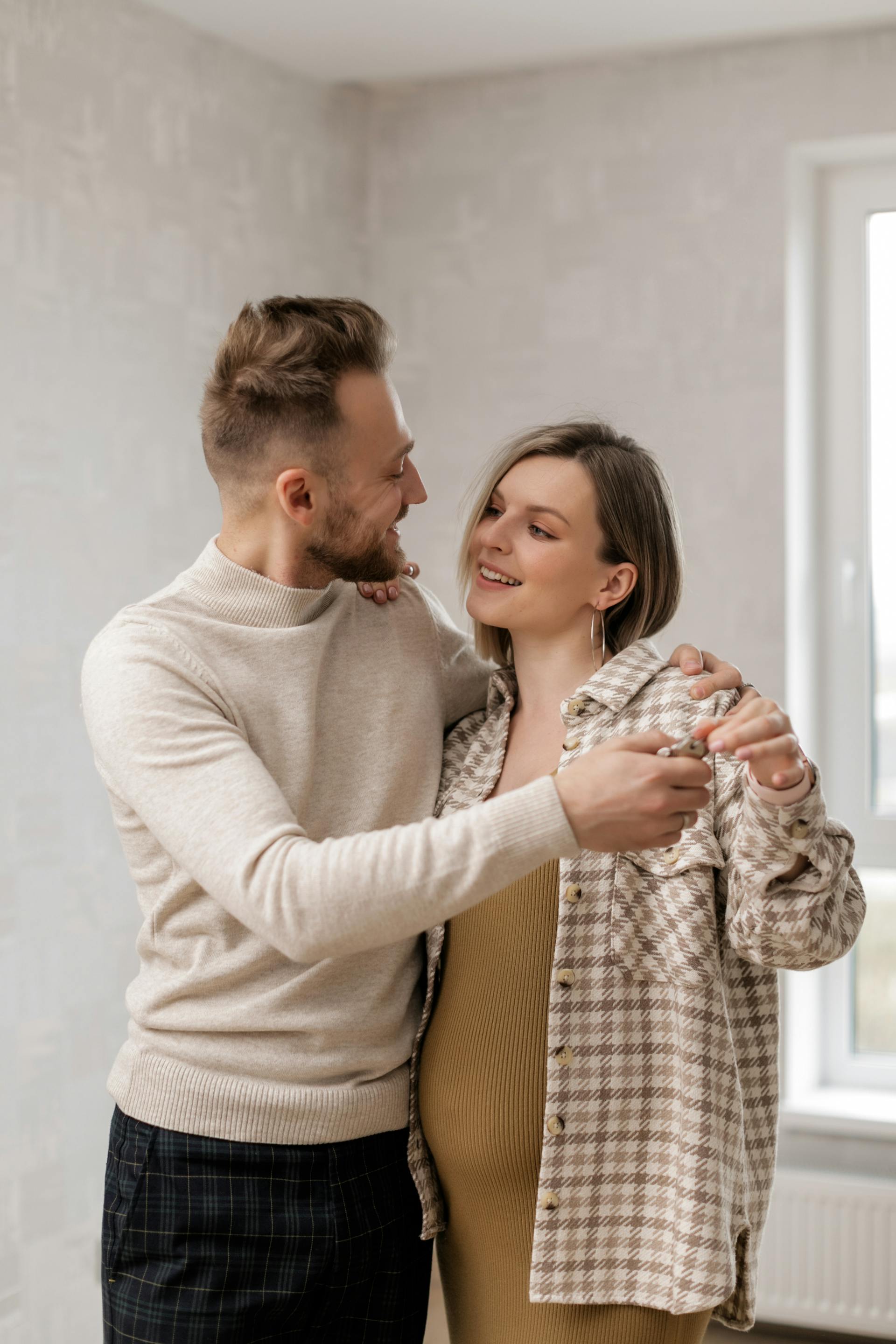 A happy pregnant couple looking at each other | Source: Pexels