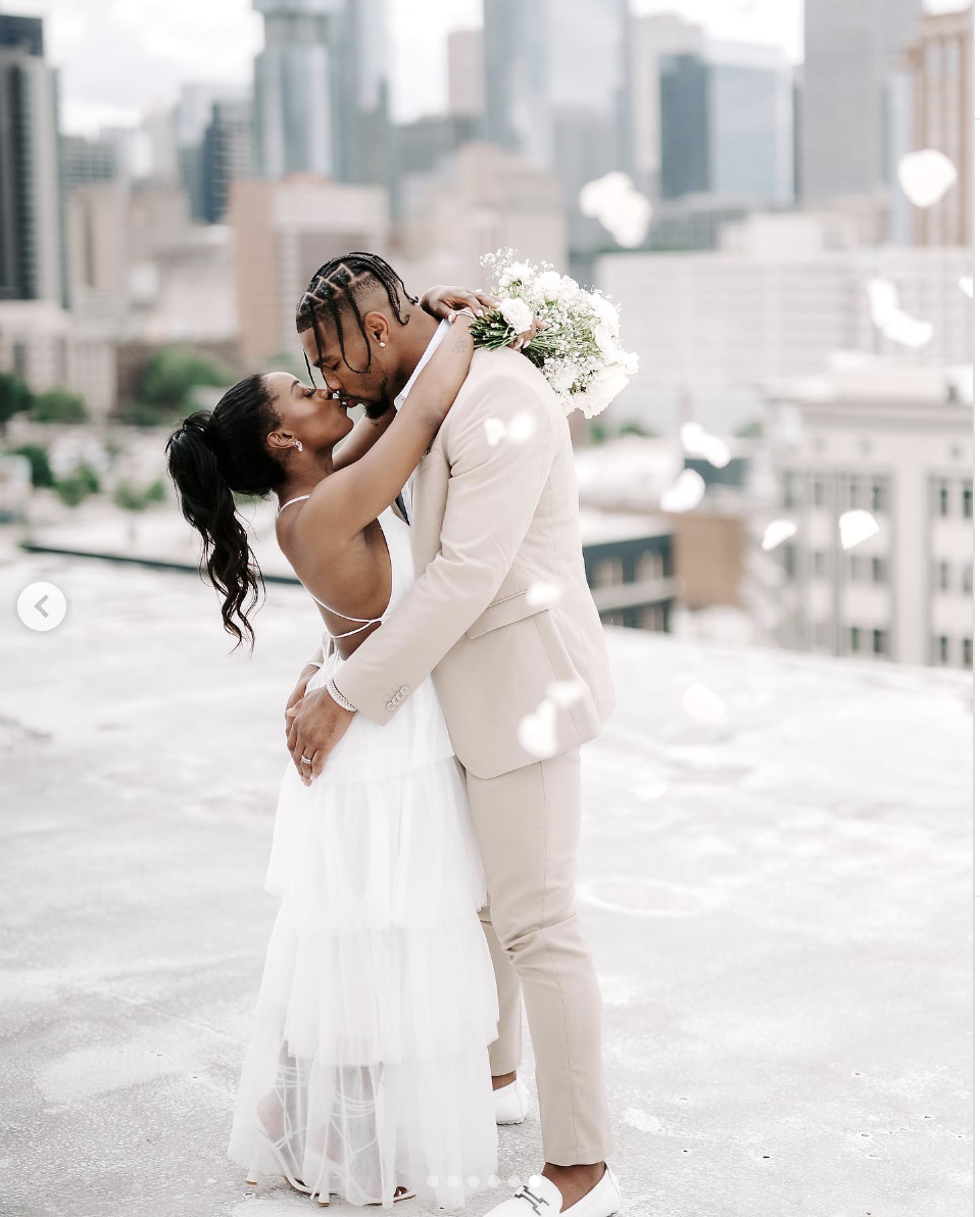 Jonathan Owens kissing Simone Biles on a rooftop on their wedding day, as seen in a post dated April 22, 2023 | Source: Instagram/simonebiles