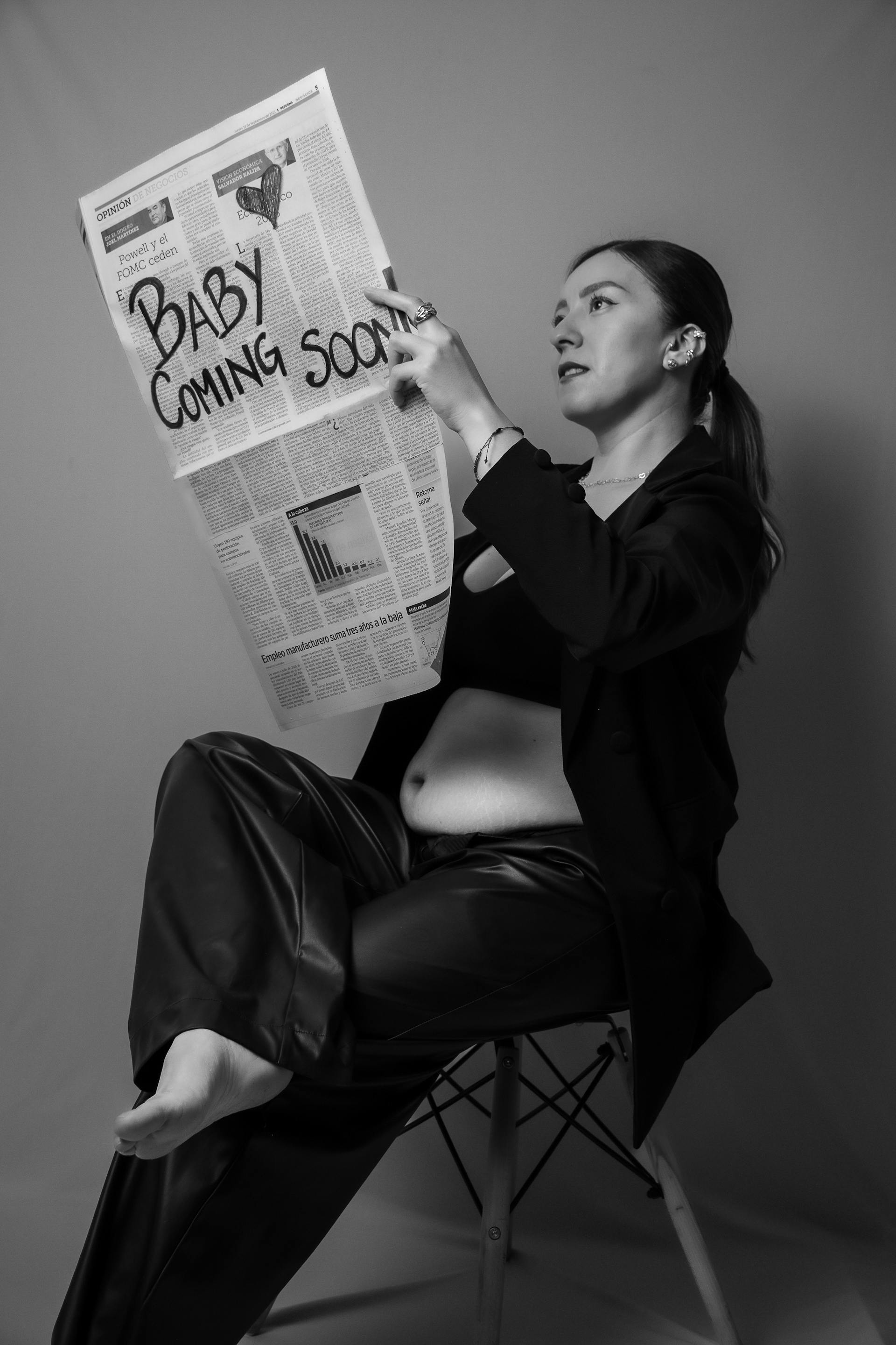 Grayscale photo of a pregnant woman holding a newspaper | Source: Pexels