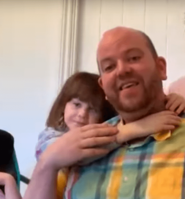 Der stolze Vater Ben Carpenter kuschelt mit einem seiner adoptierten Kinder. | Quelle: Youtube.com/This Morning