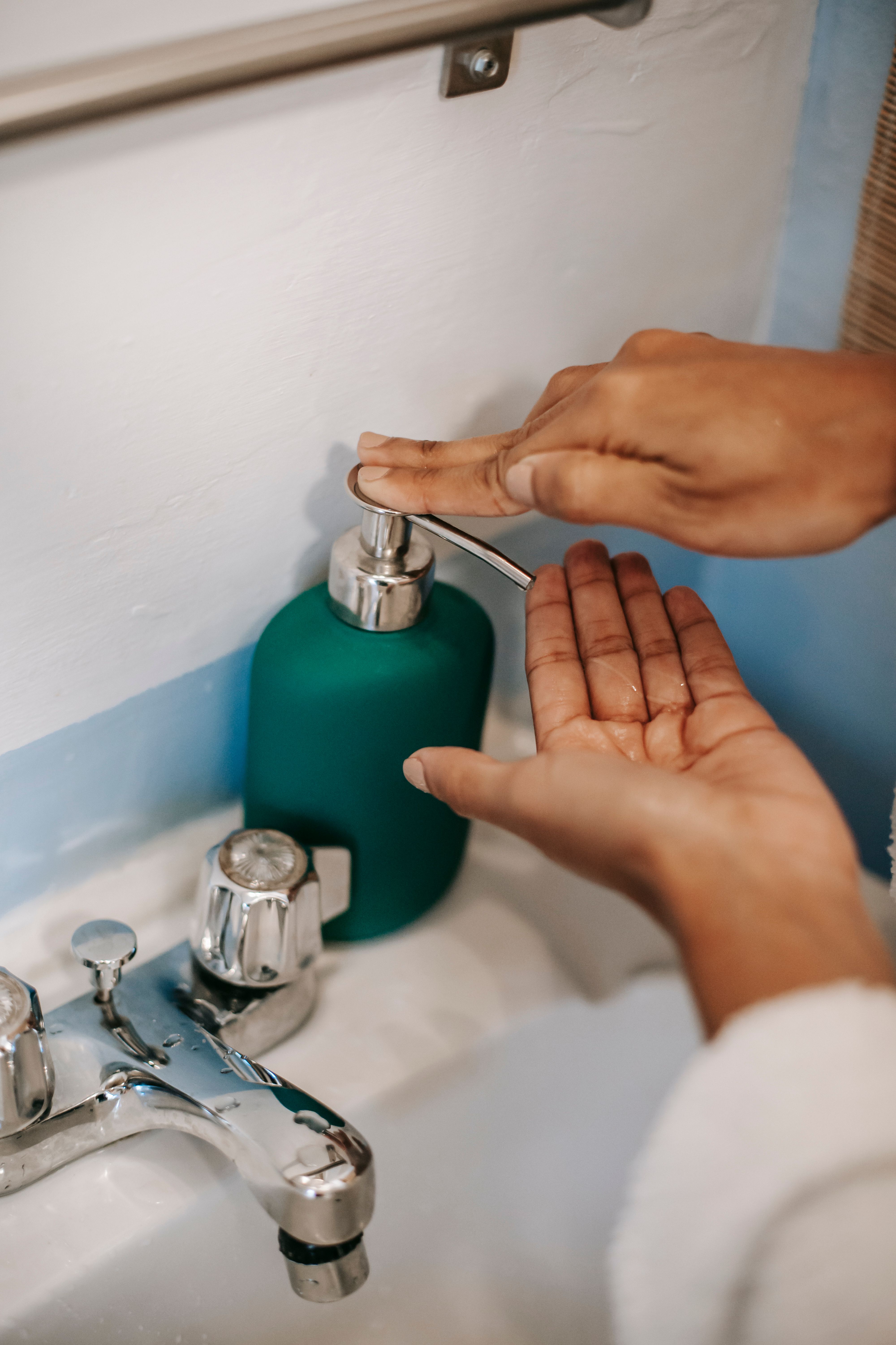 A person using a liquid soap dispenser | Source: Pexels