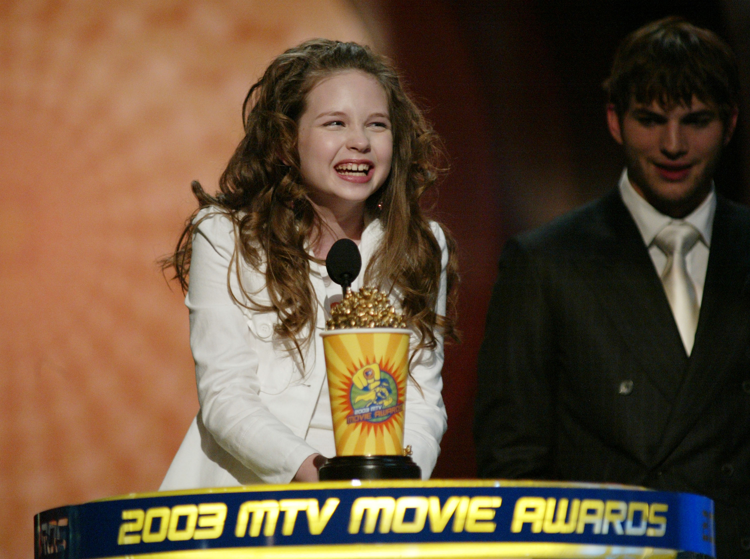 Daveigh Chase accepts an award onstage alongside Ashton Kutcher during the 2003 MTV Movie Awards after winning Best Villain for her performance in "The Ring." | Source: Getty Images