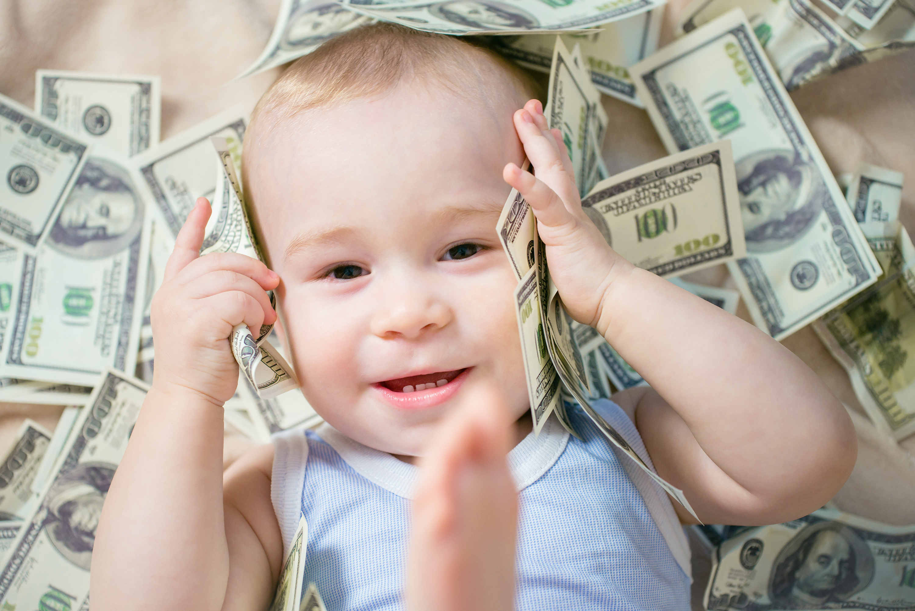 Baby boy covered with money | Source: Shutterstock
