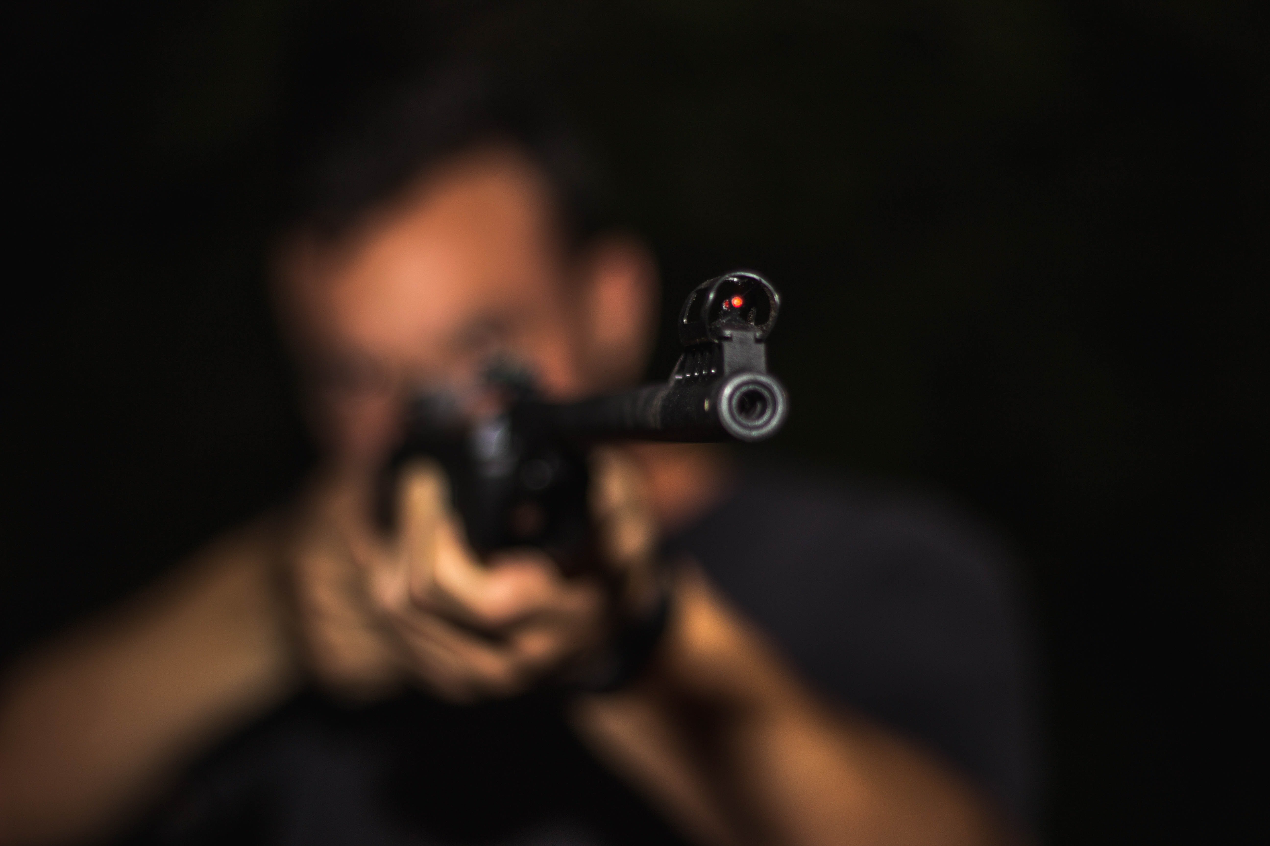 Pictured - A photo of a man holding a rifle and aiming | Source: Pexels 