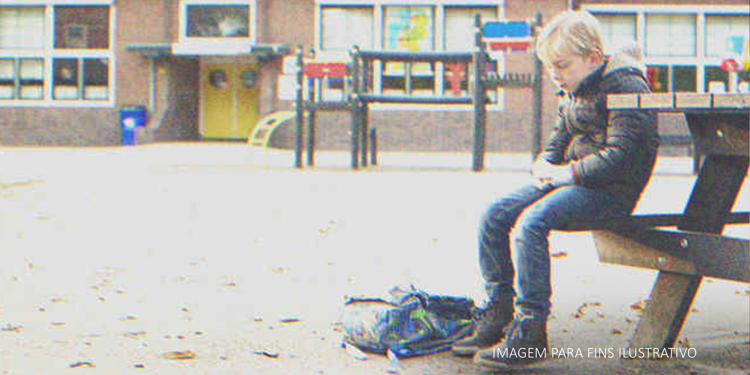 Um menino sentado sozinho em um banco do lado de fora de uma escola | Foto: Shutterstock