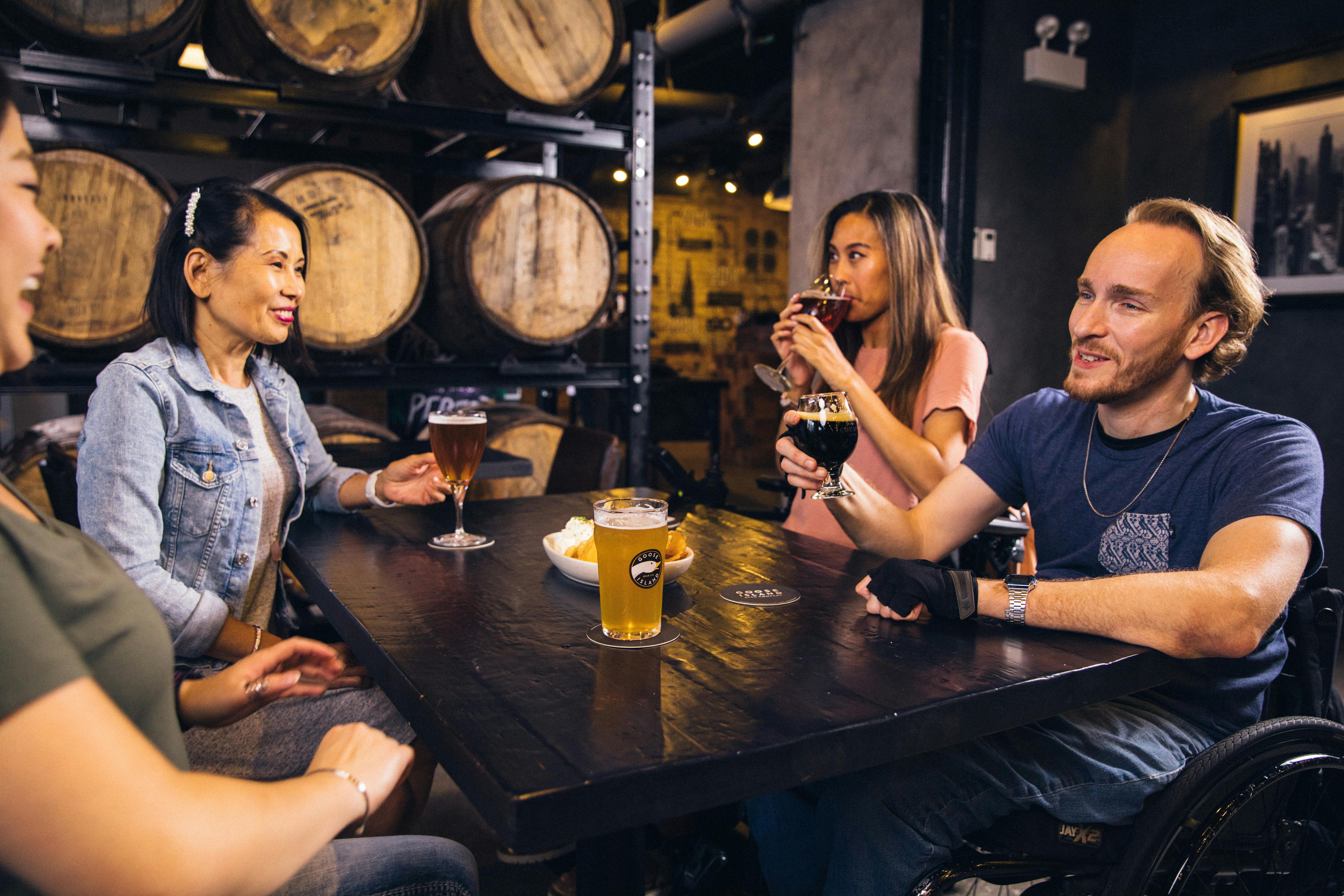 People seated around a table and drinking beer | Source: Pexels