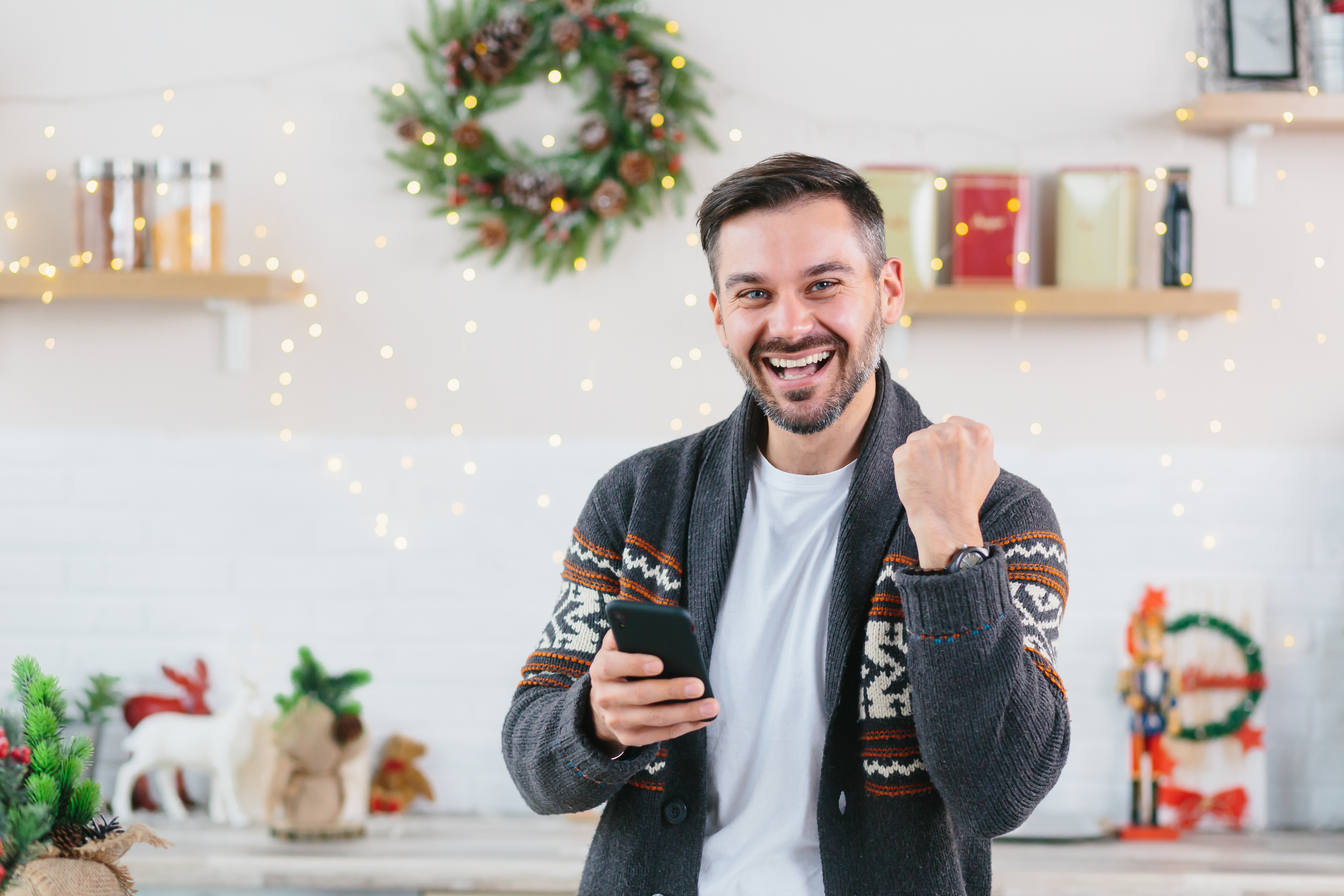 Young man celebrating a victory at home during Christmas | Source: Shutterstock