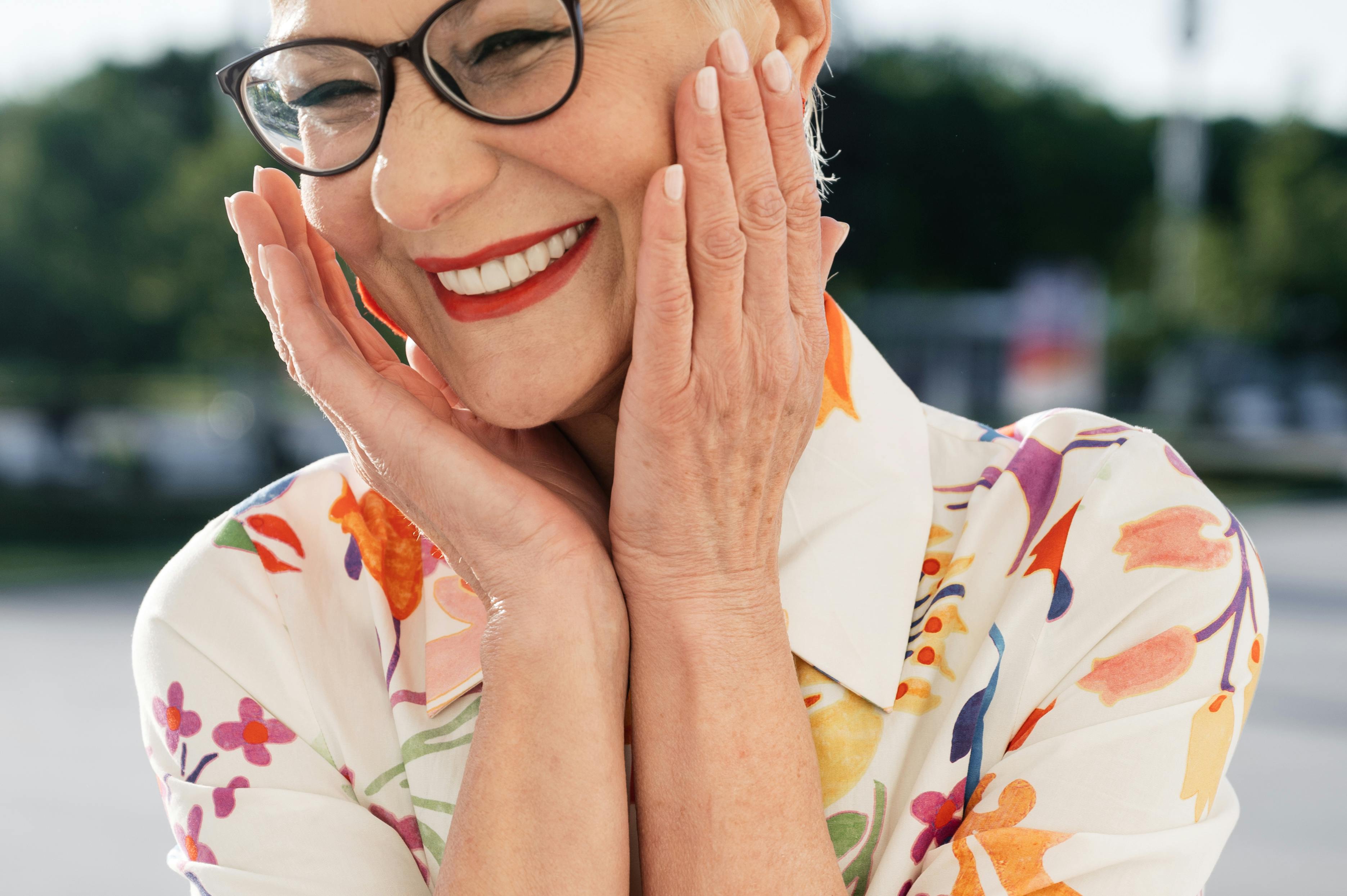 A smiling woman touching her face | Source: Pexels