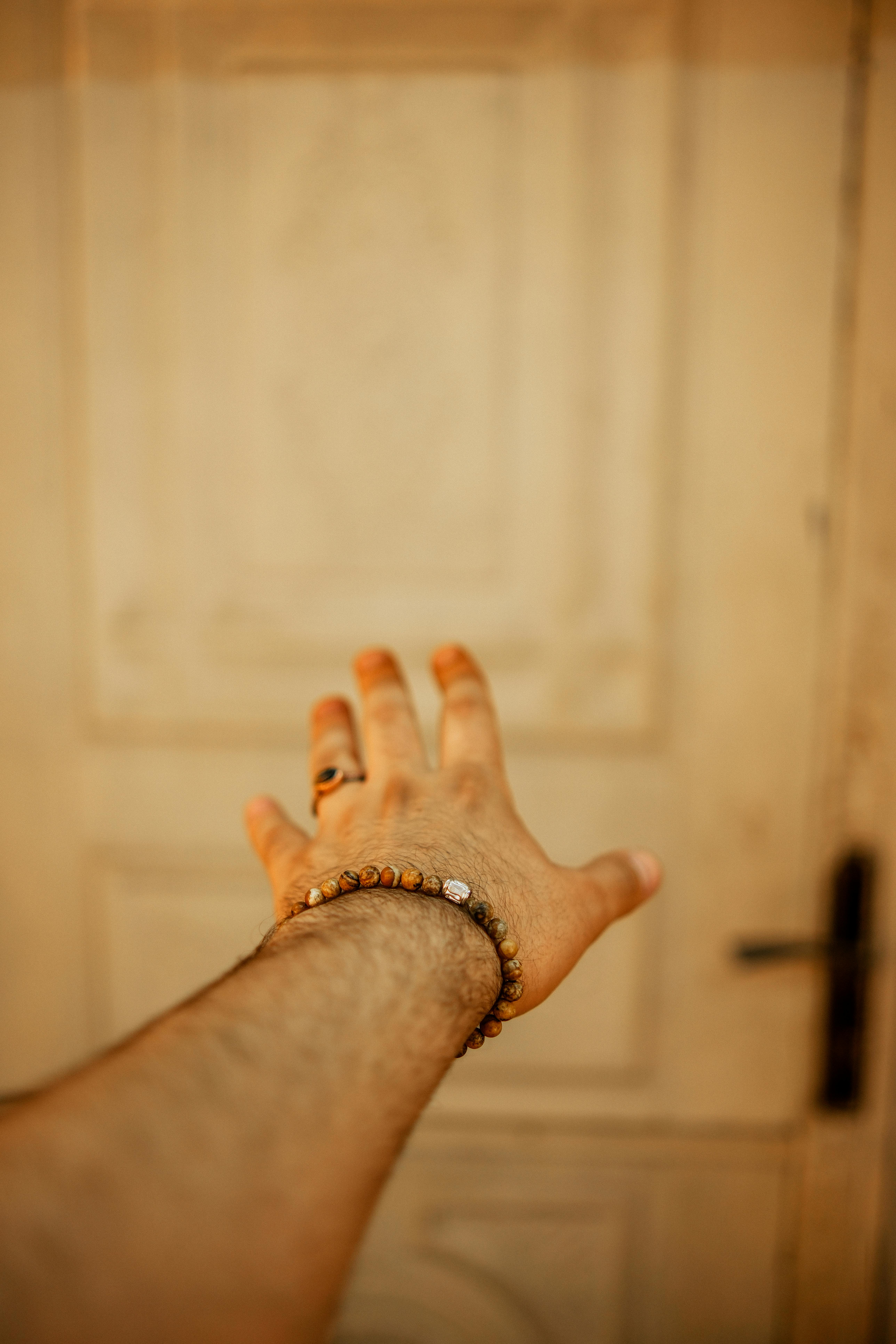 A man's hand reaching out to a closed door | Source: Pexels